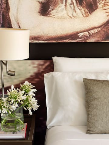 a lamp on a table next to a bed