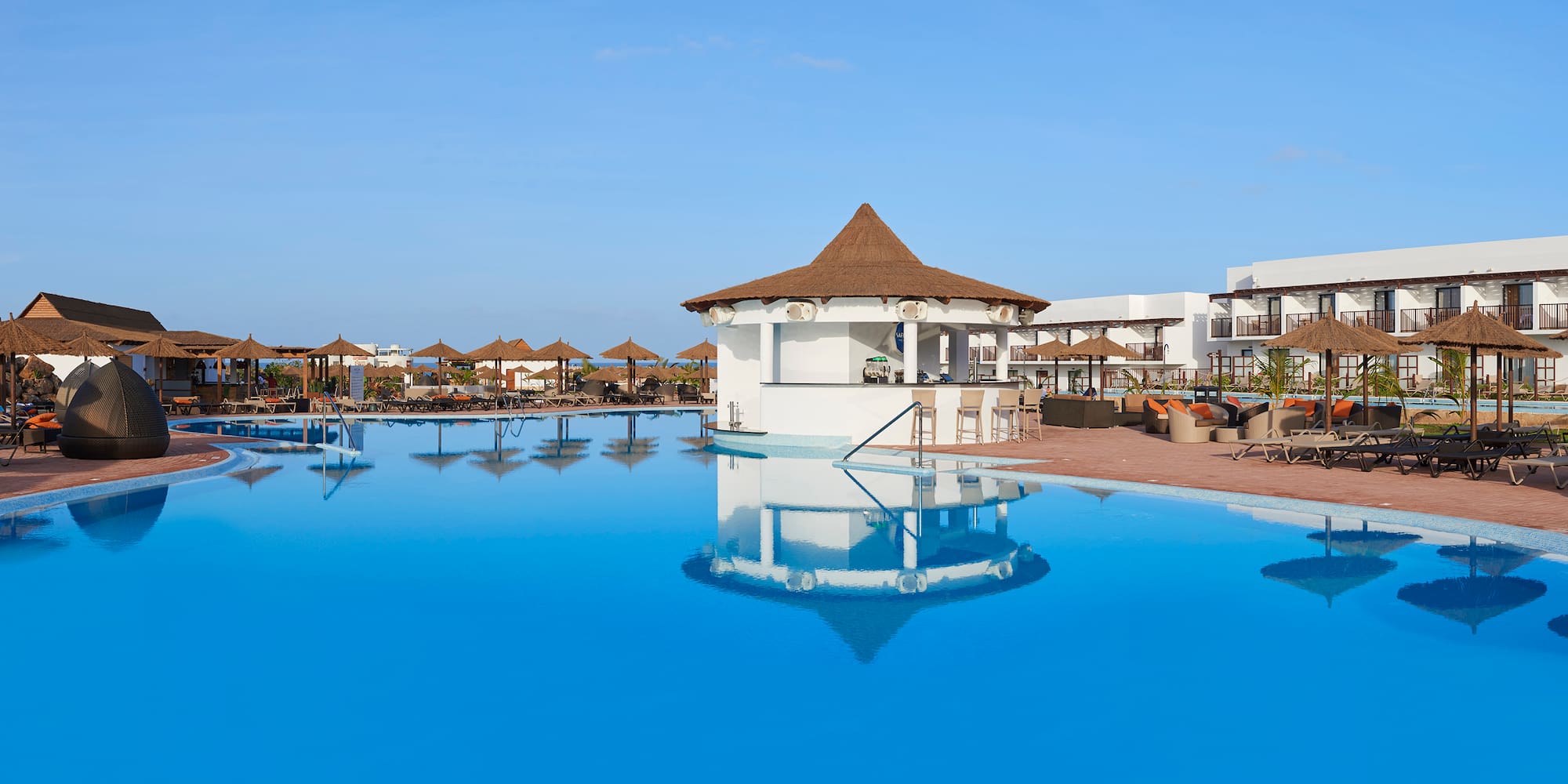a pool with a gazebo and umbrellas