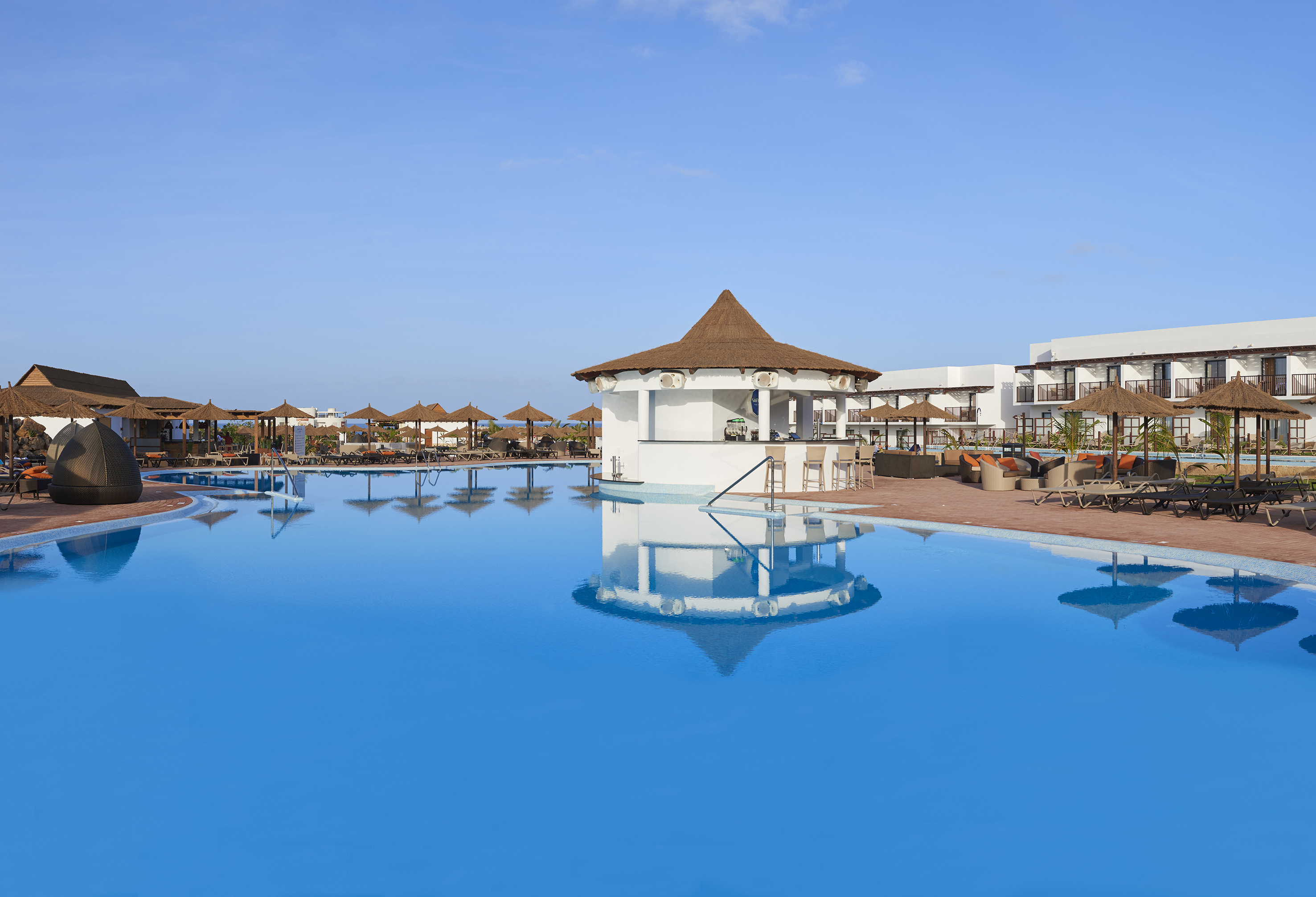 a pool with a gazebo and umbrellas