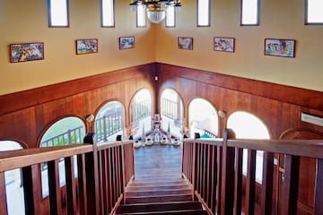 a staircase with a chandelier and art on the wall
