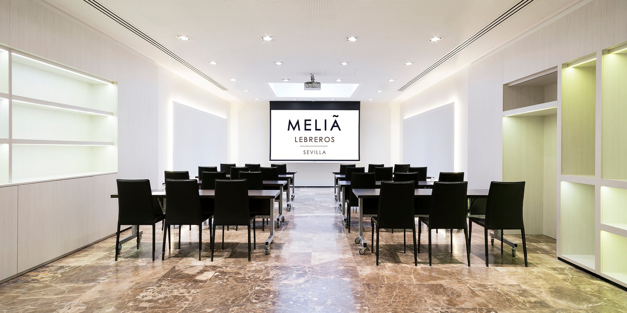 a room with a large screen and chairs