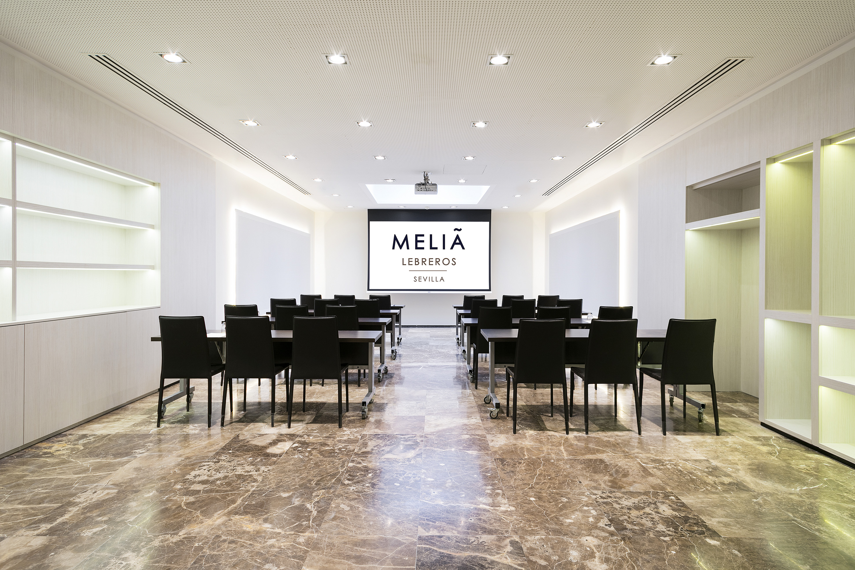 a room with a large screen and chairs