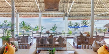 a room with a large roof and chairs and a table