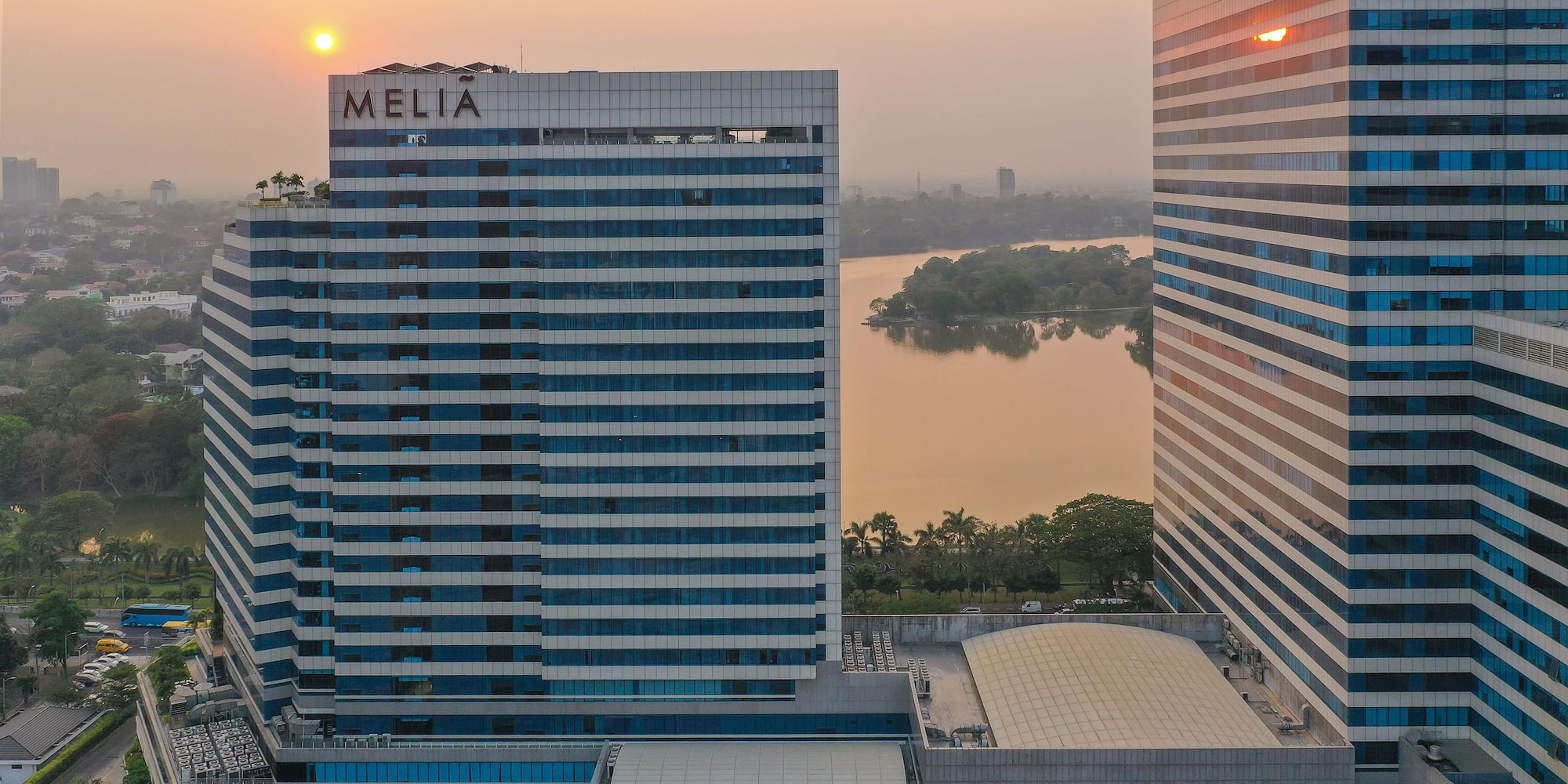 a group of tall buildings with a body of water in the background