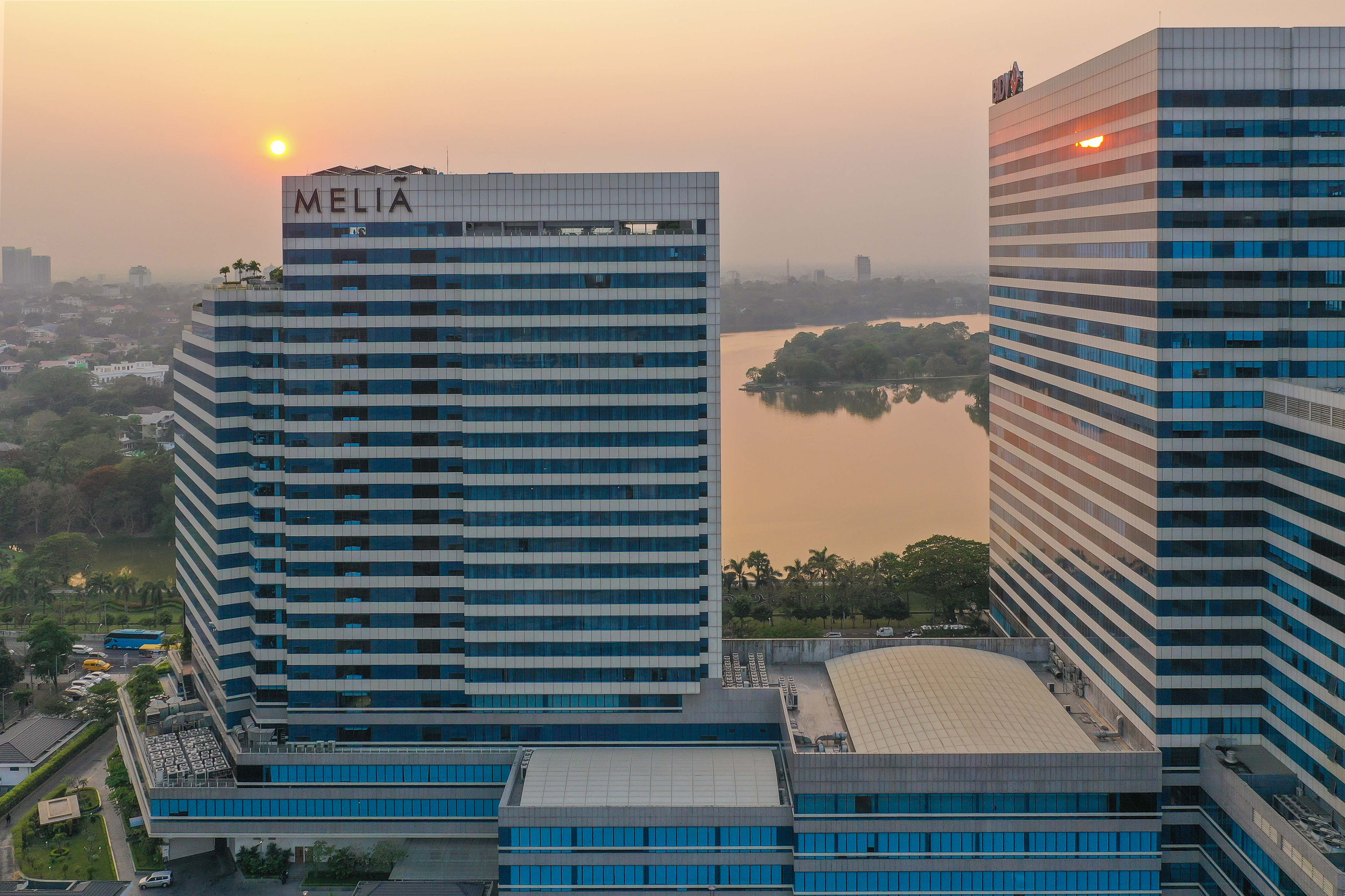 a group of tall buildings with a body of water in the background