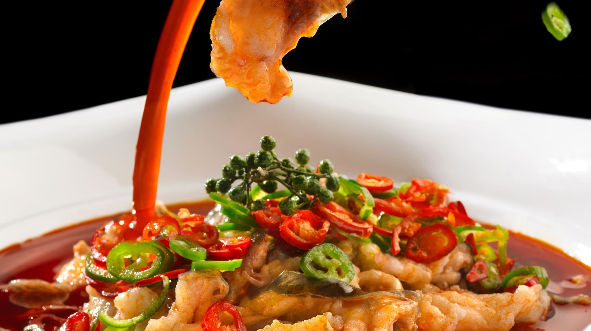 a bowl of food with sauce being poured into it