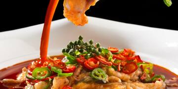 a bowl of food with sauce being poured into it