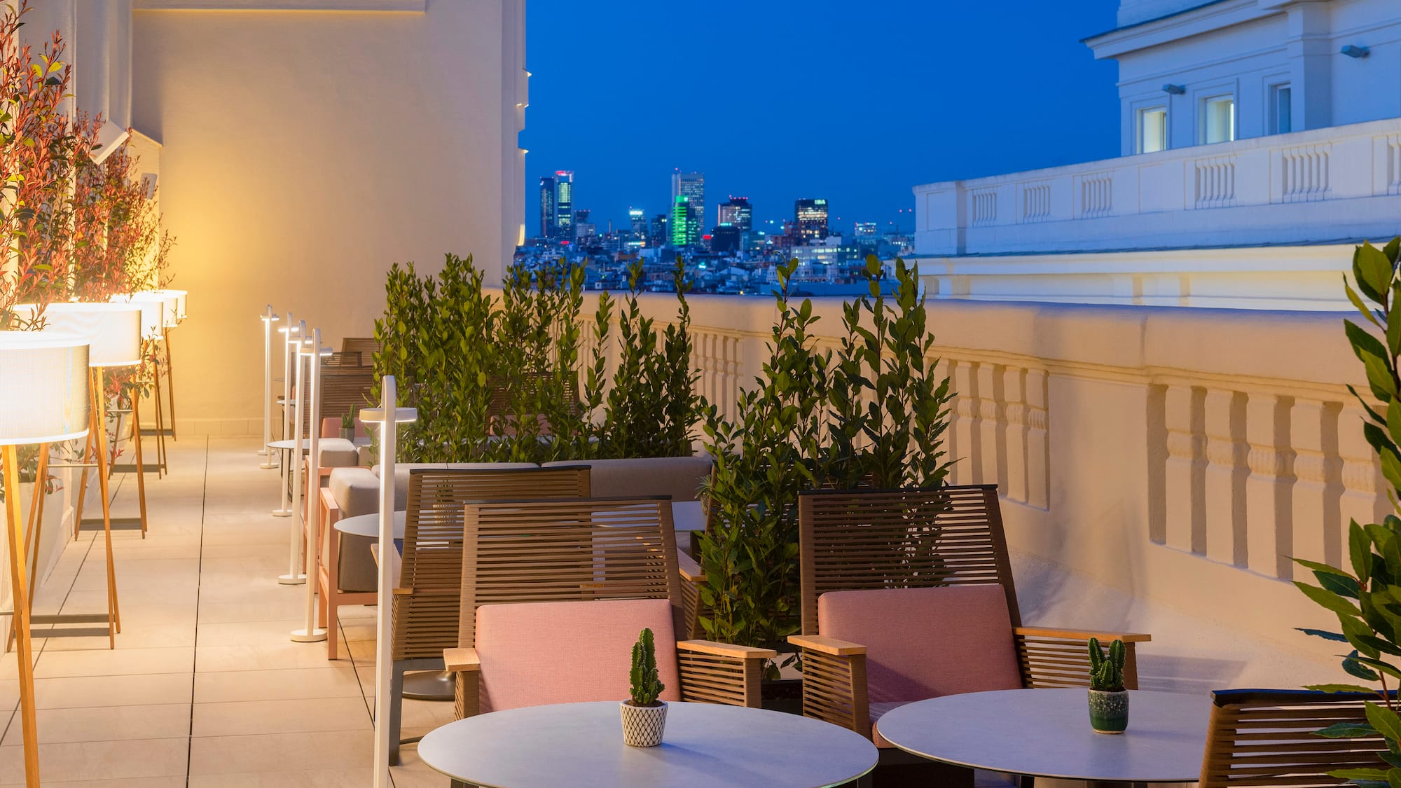 a patio with tables and chairs on a rooftop