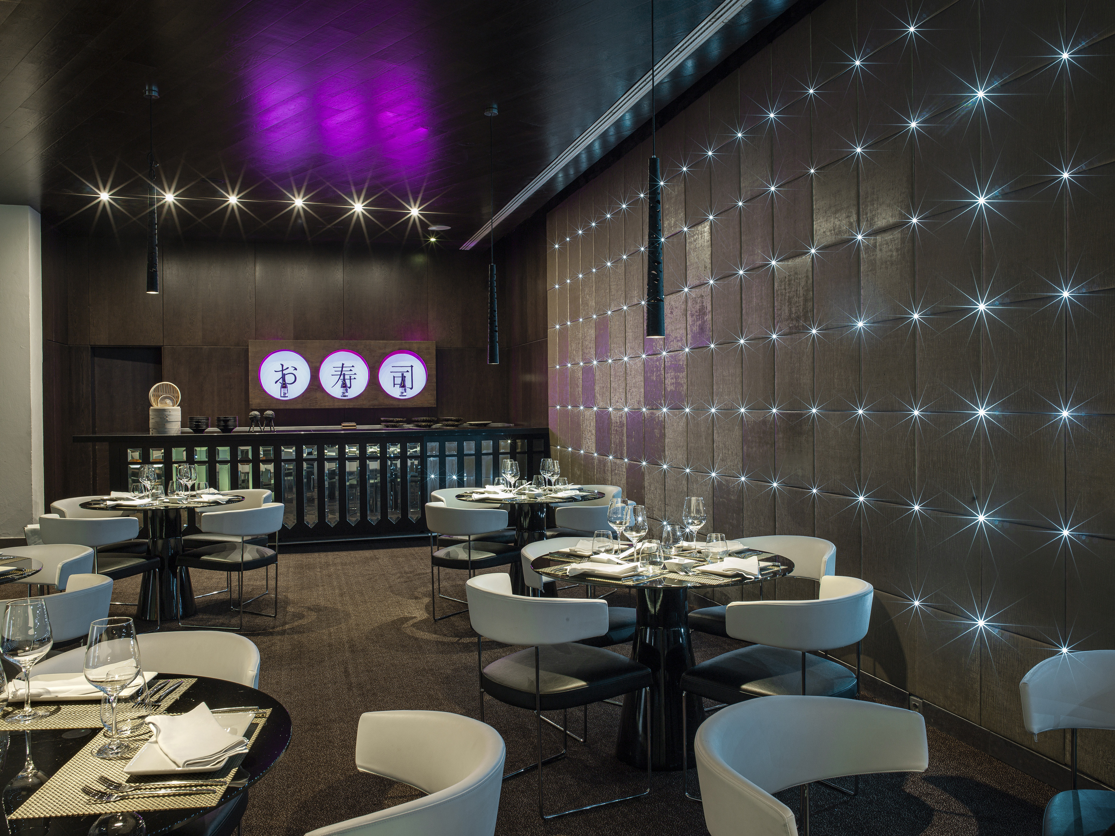 Elegant sushi restaurant dining room with star wall lights and purple accents.