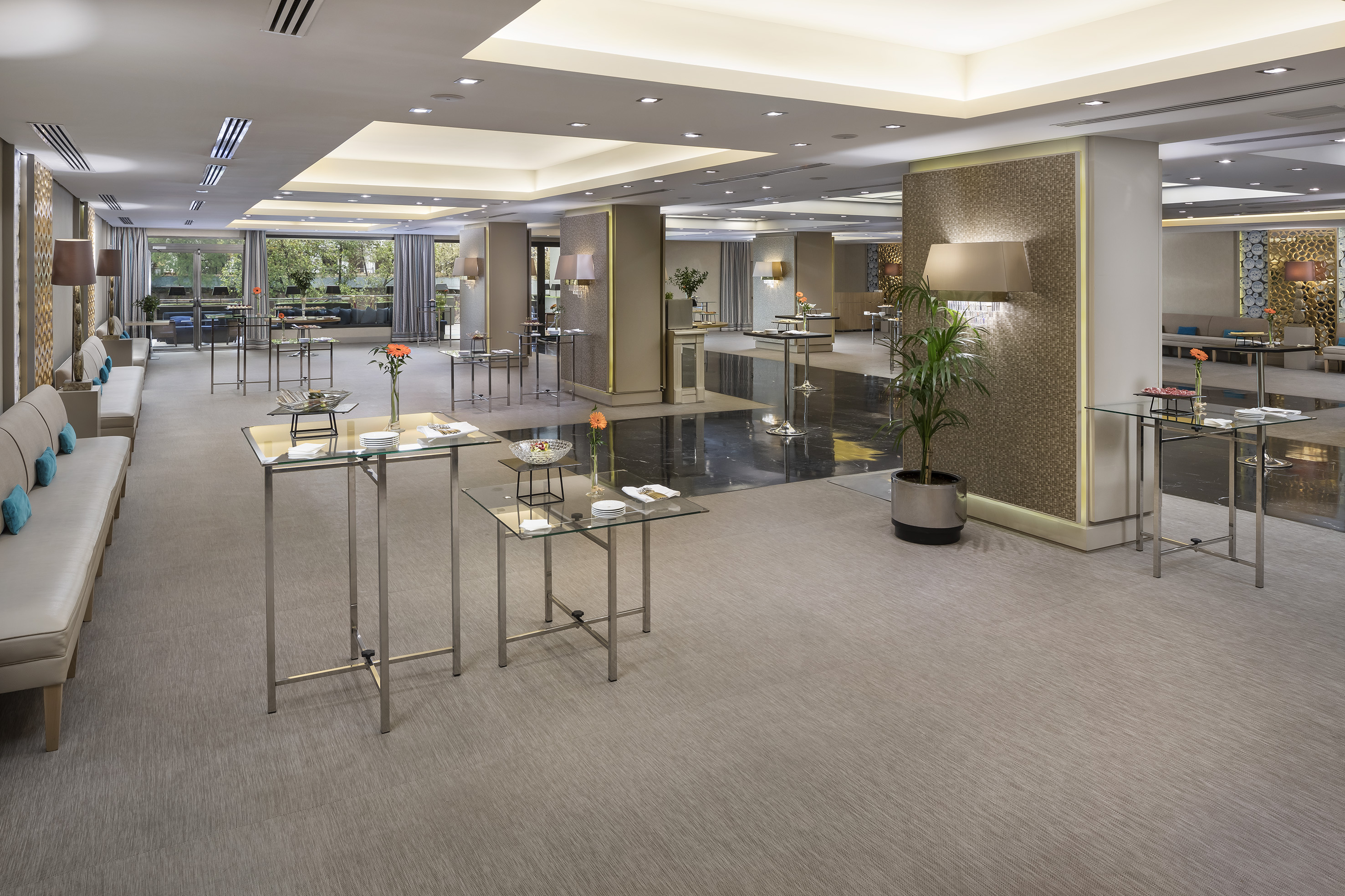 Elegant hotel event reception area with modern decor and glass tables.