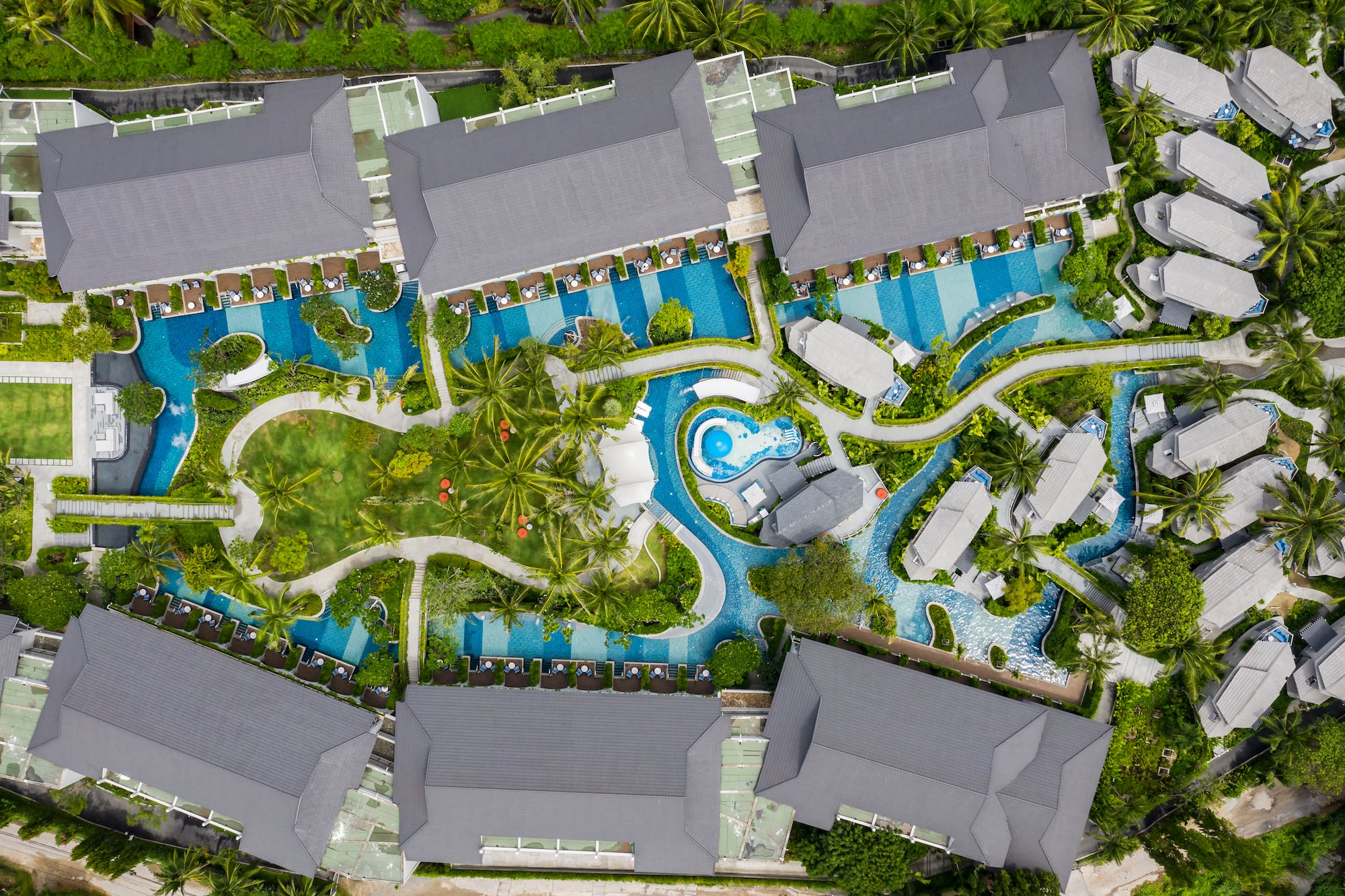 a aerial view of a resort with swimming pools and trees