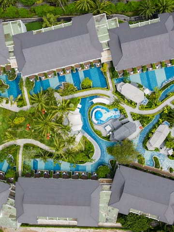 a aerial view of a resort with swimming pools and trees