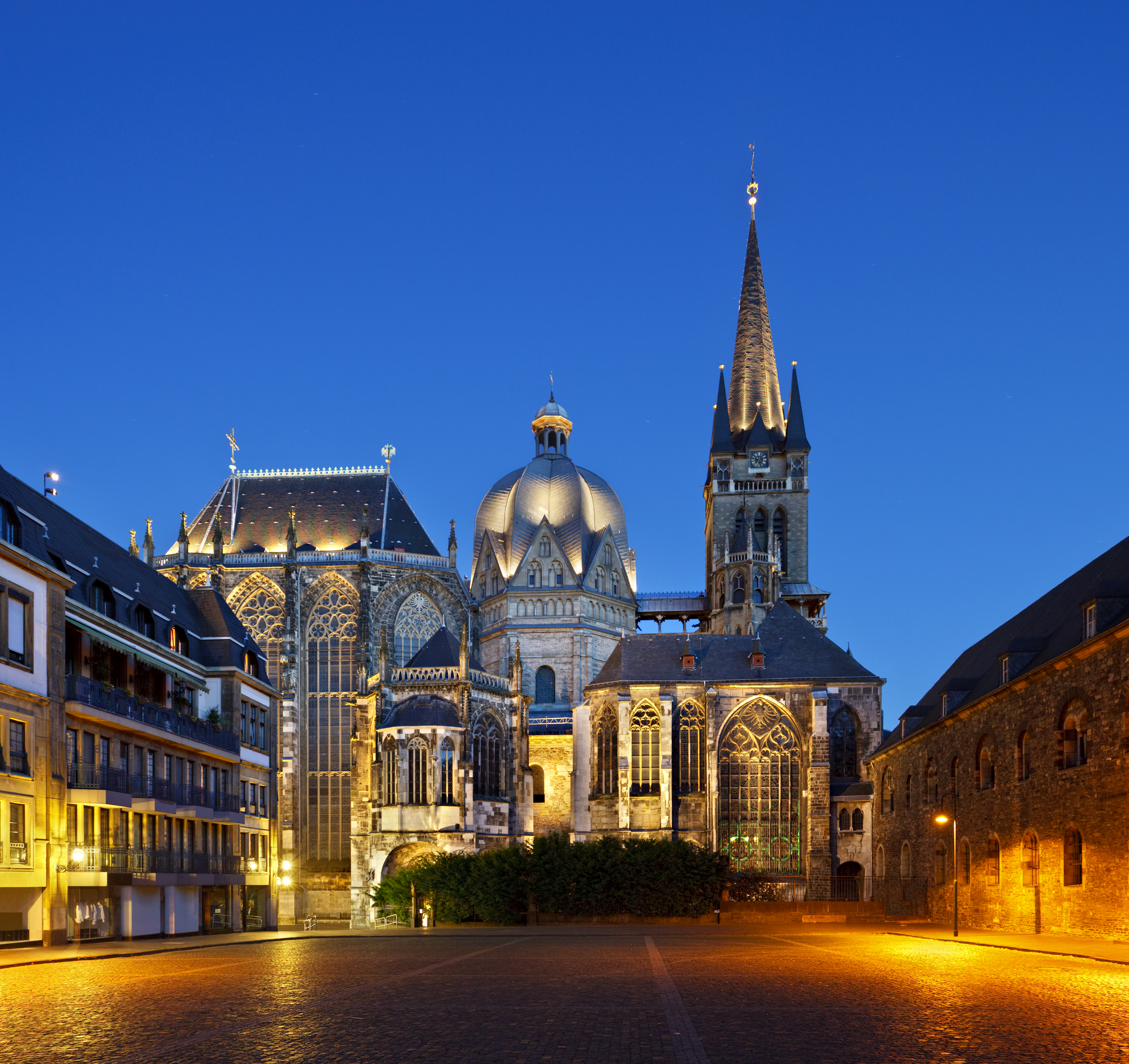 Night view of Aachen Cathedral, Germany, with its iconic dome and Gothic facade.