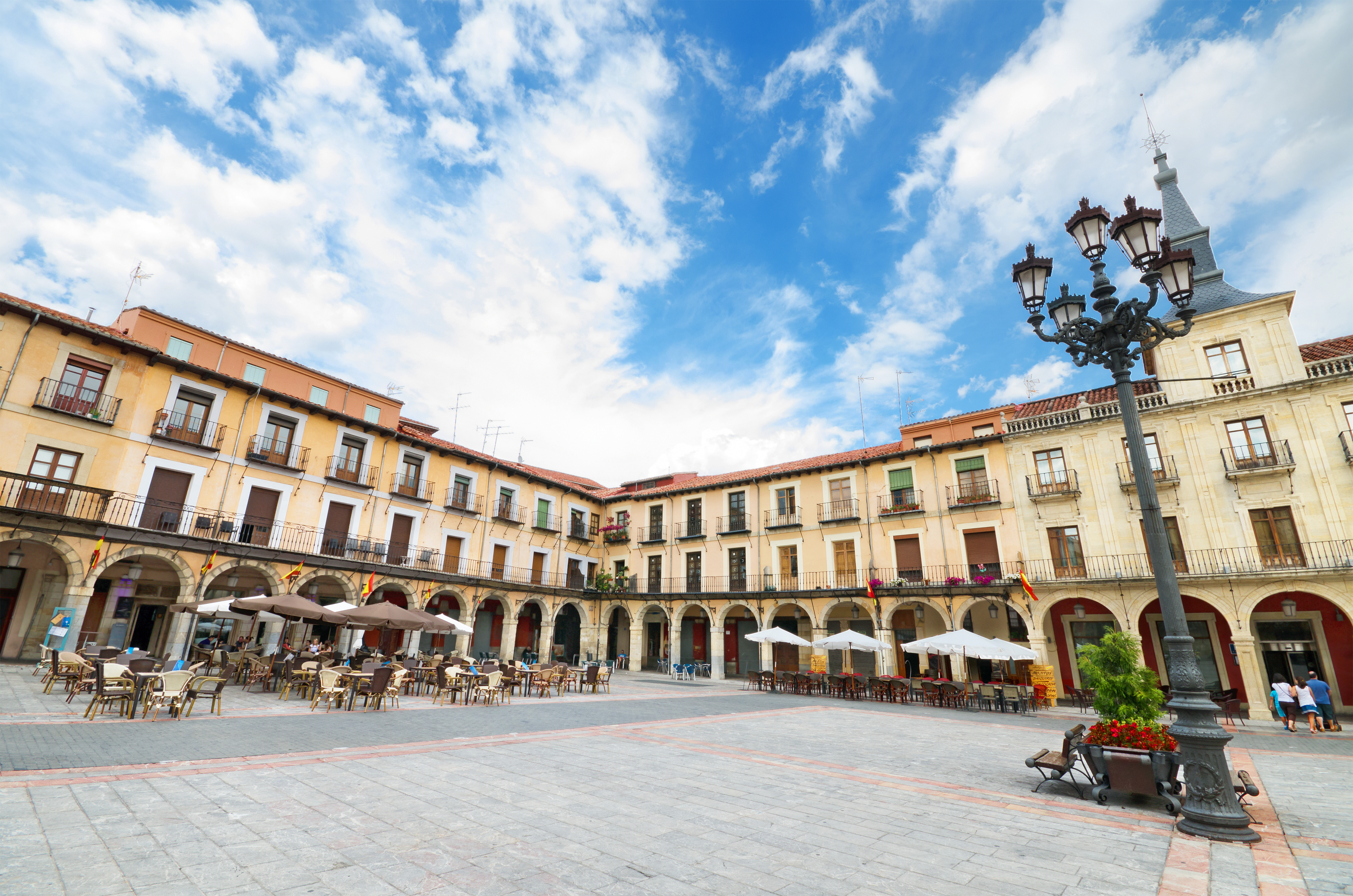 a courtyard with tables and chairs in front of a building