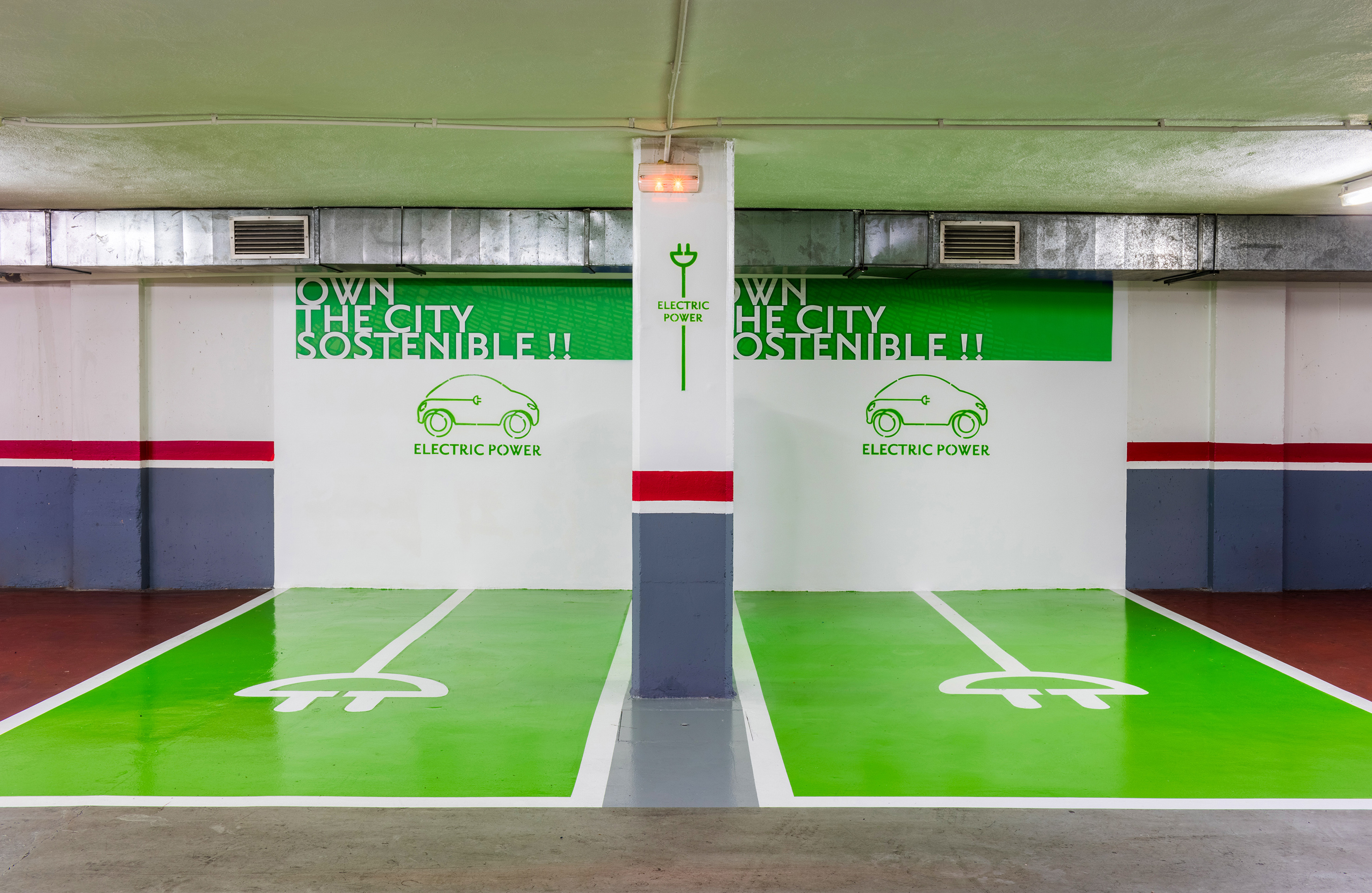 Green electric vehicle charging bays in a sustainable parking garage.