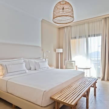 a bed with a bench and a lamp from the ceiling