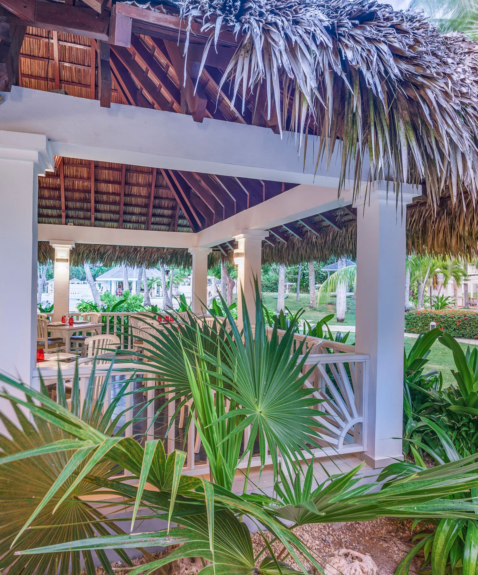 a gazebo with palm trees and grass