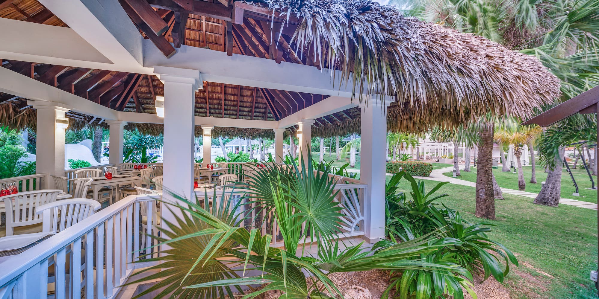 a gazebo with palm trees and grass