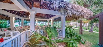 a gazebo with palm trees and grass