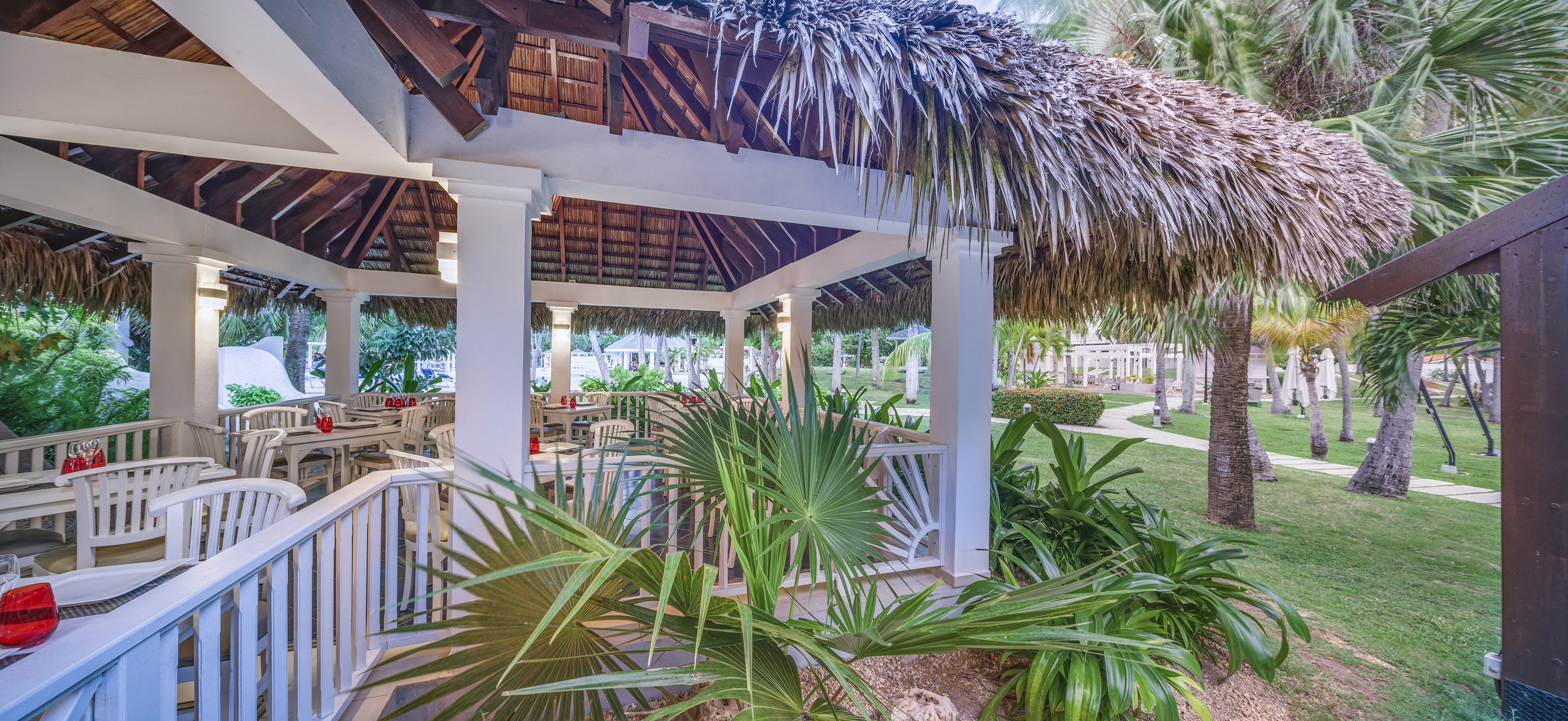 a gazebo with palm trees and grass