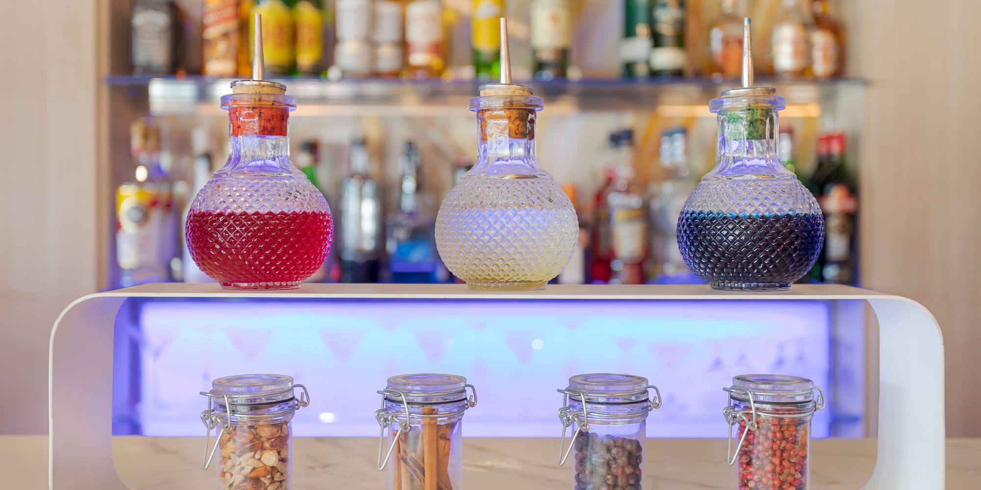 a group of glass jars with different colored liquid on a counter