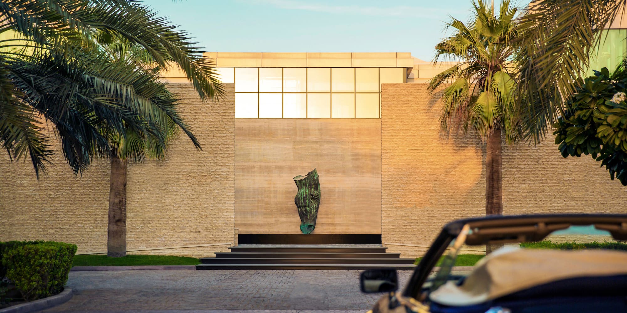 a car parked in front of a building with palm trees