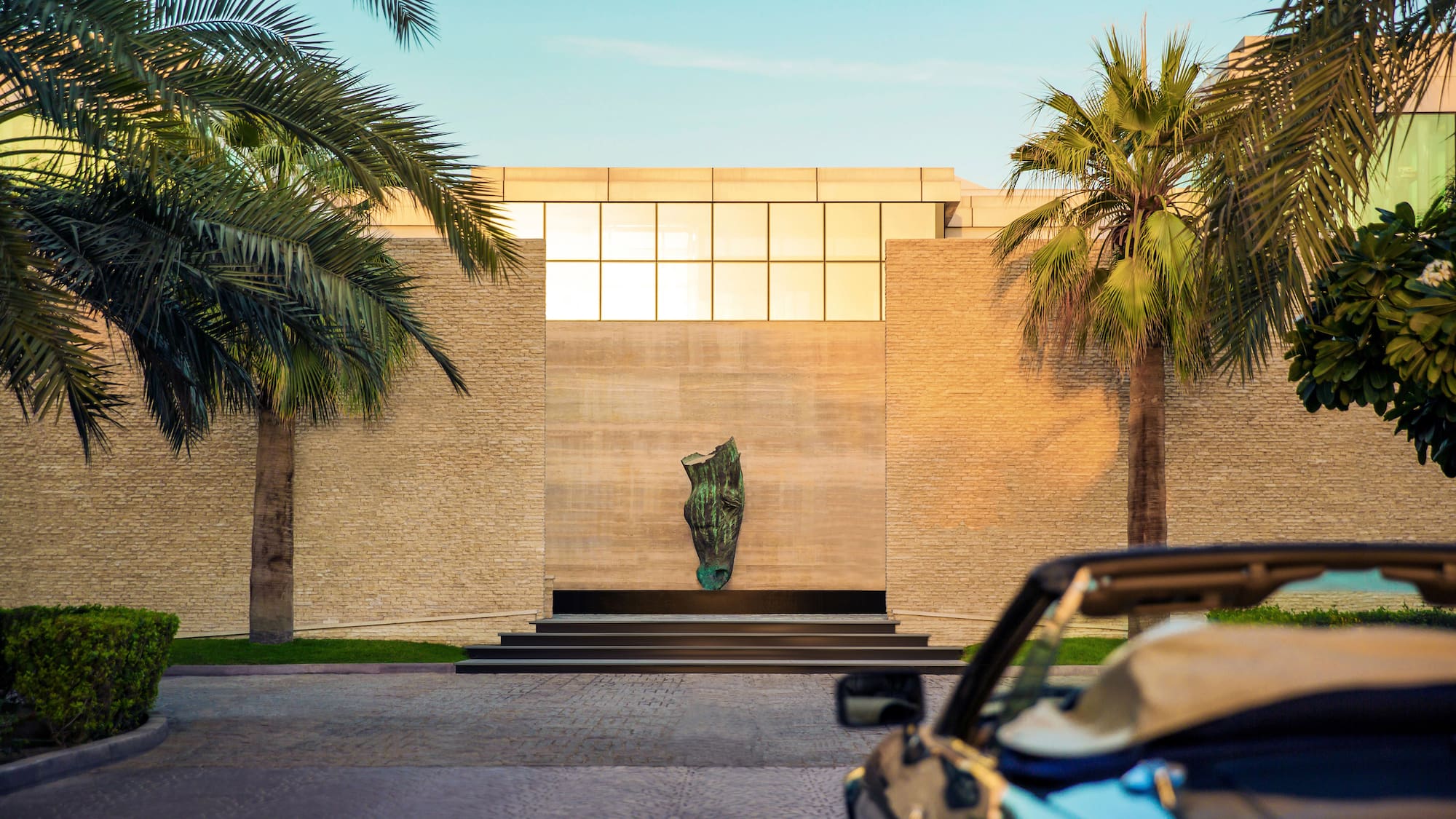 a car parked in front of a building with palm trees