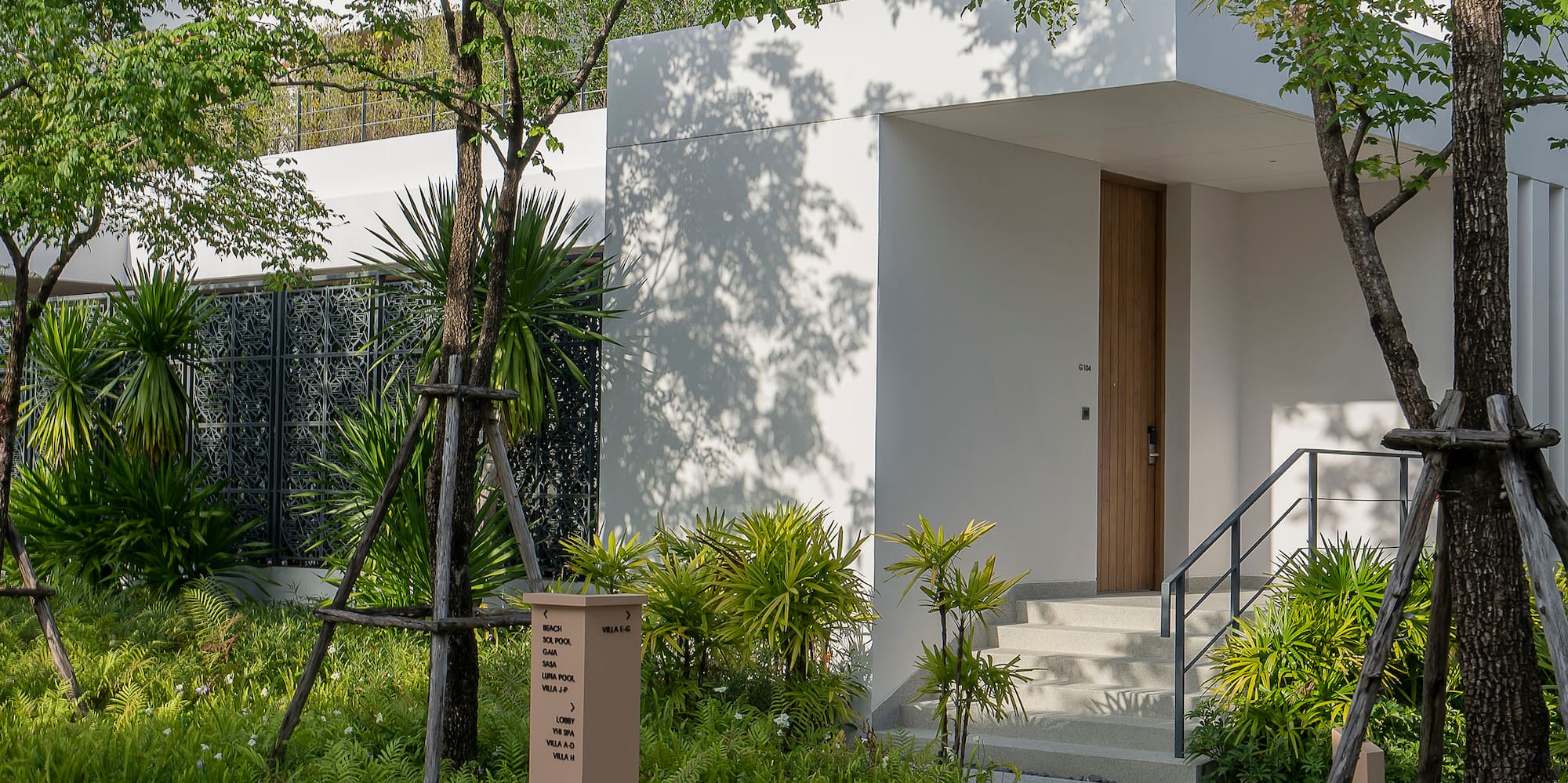 a white building with trees and a walkway