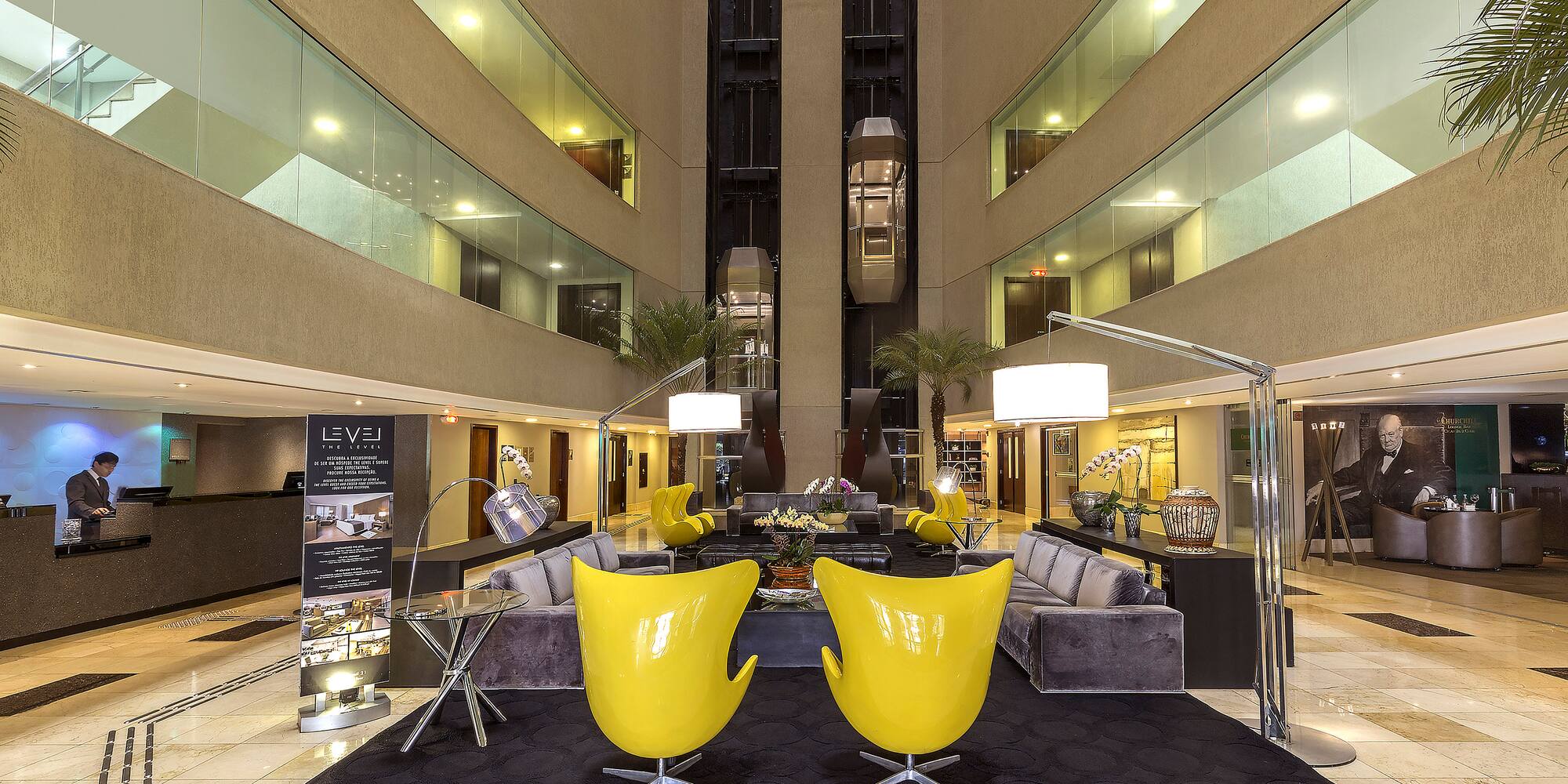a lobby with yellow chairs and a black carpet