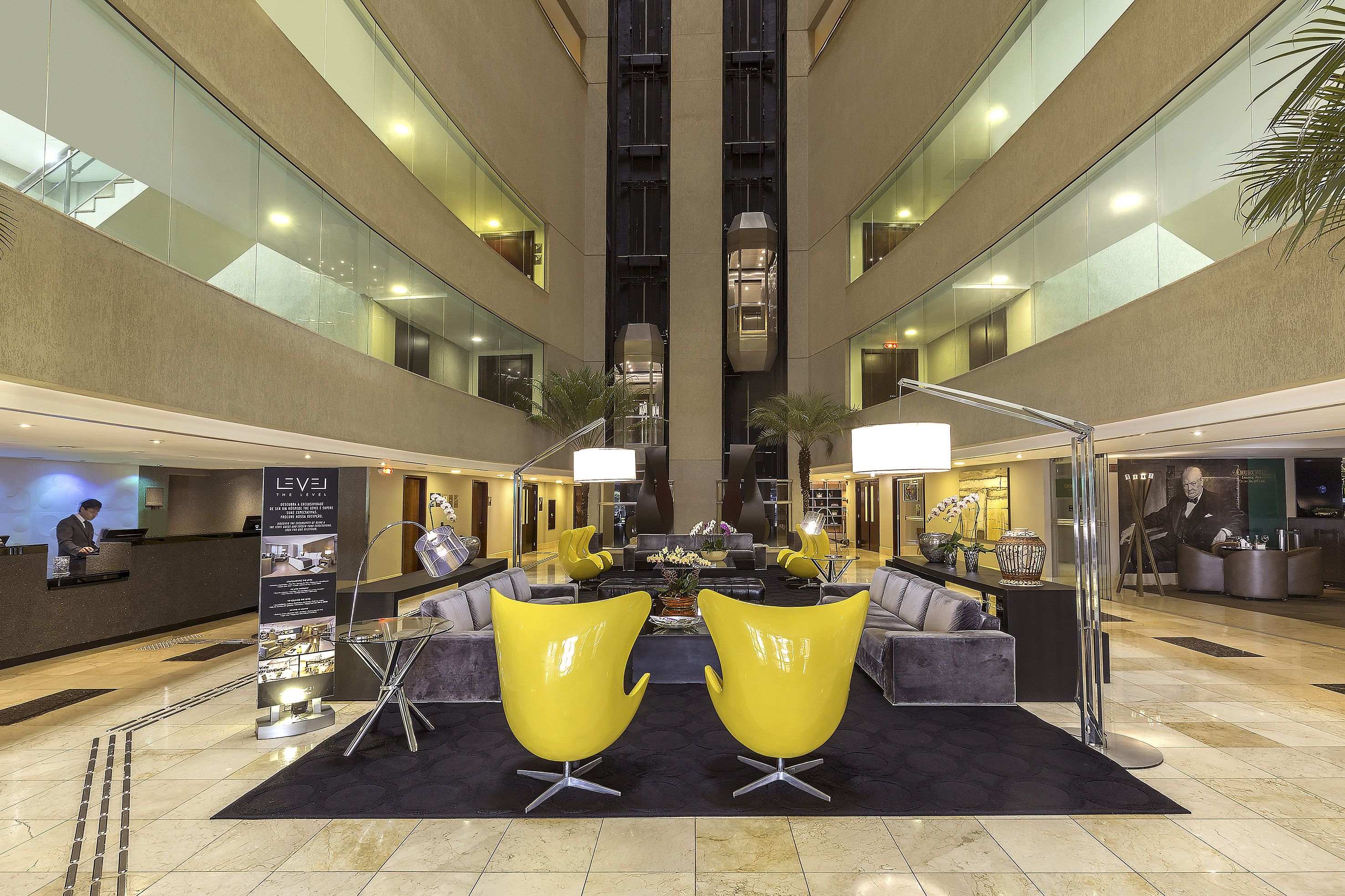 a lobby with yellow chairs and a black carpet
