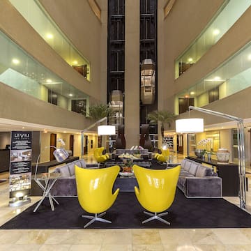 a lobby with yellow chairs and a black carpet