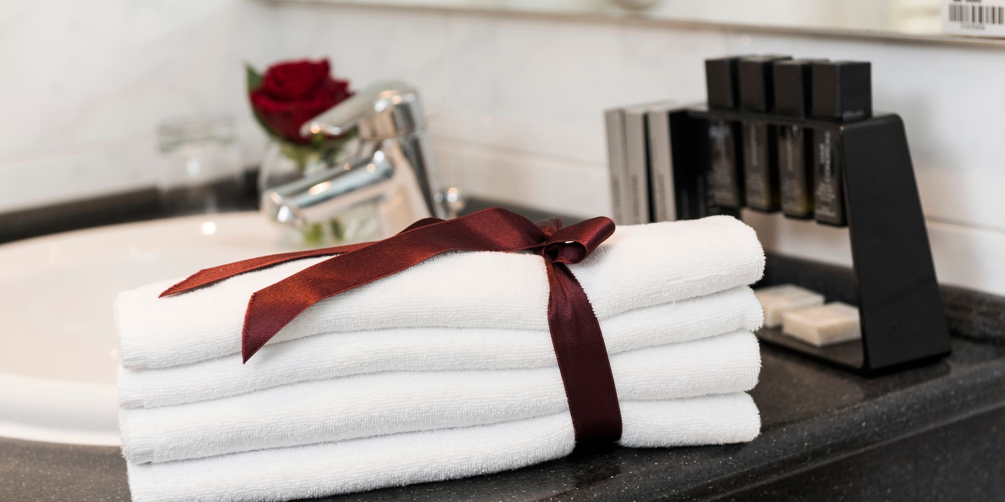 a stack of towels with a bow on a counter top