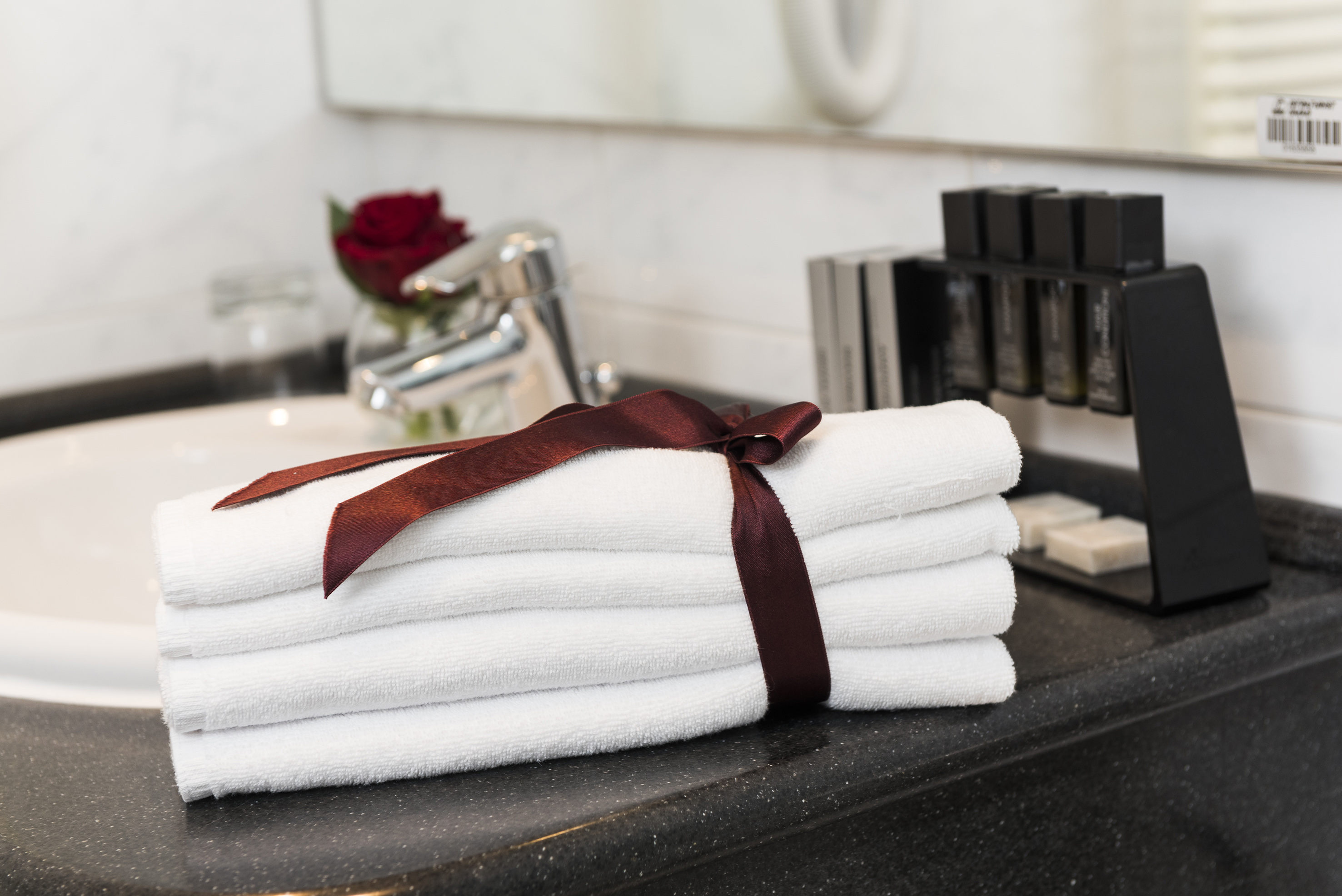 a stack of towels with a bow on a counter top