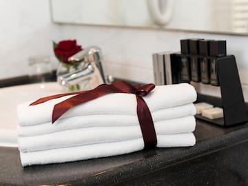 a stack of towels with a bow on a counter top