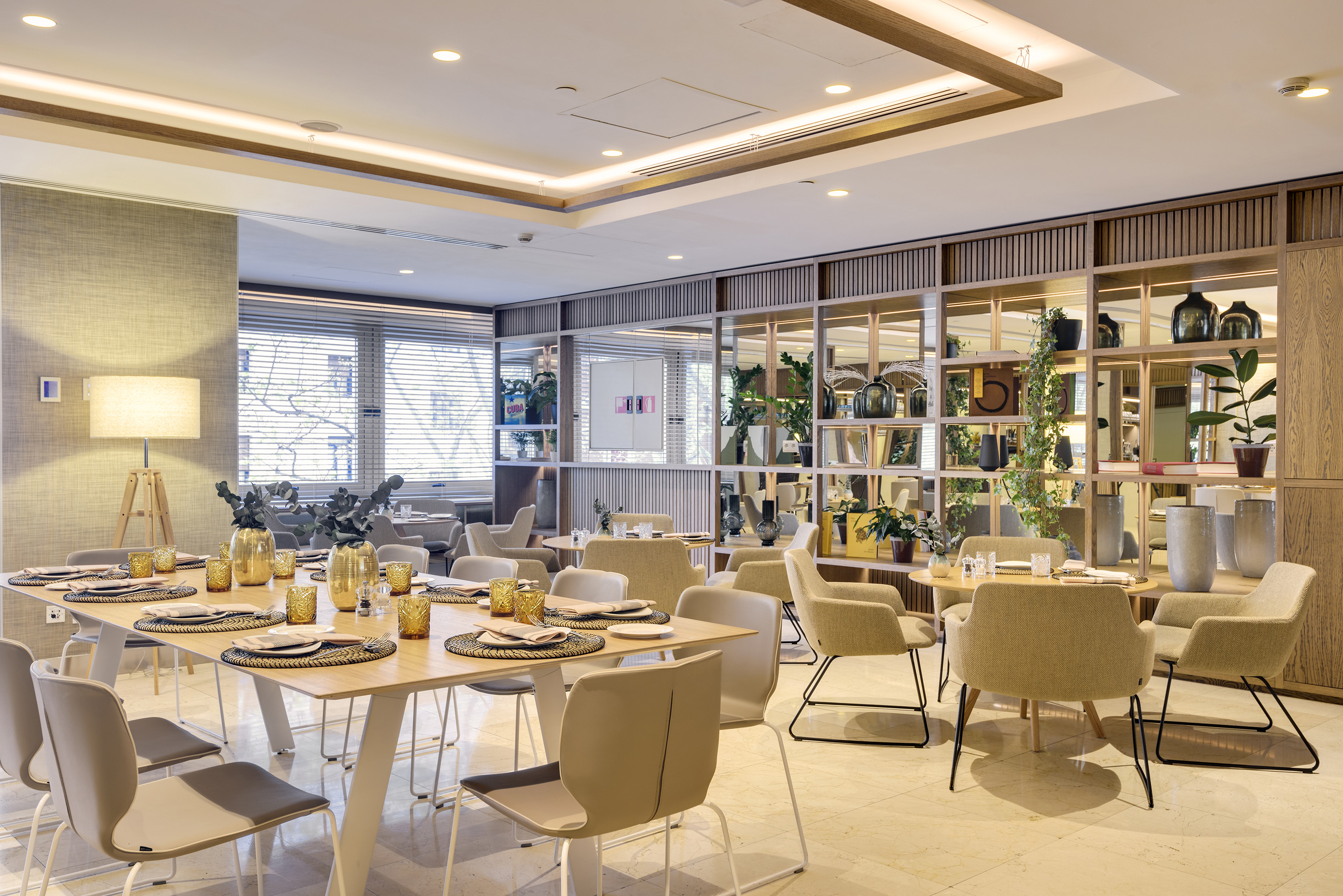 Modern restaurant interior with elegantly set tables and decorative shelving.