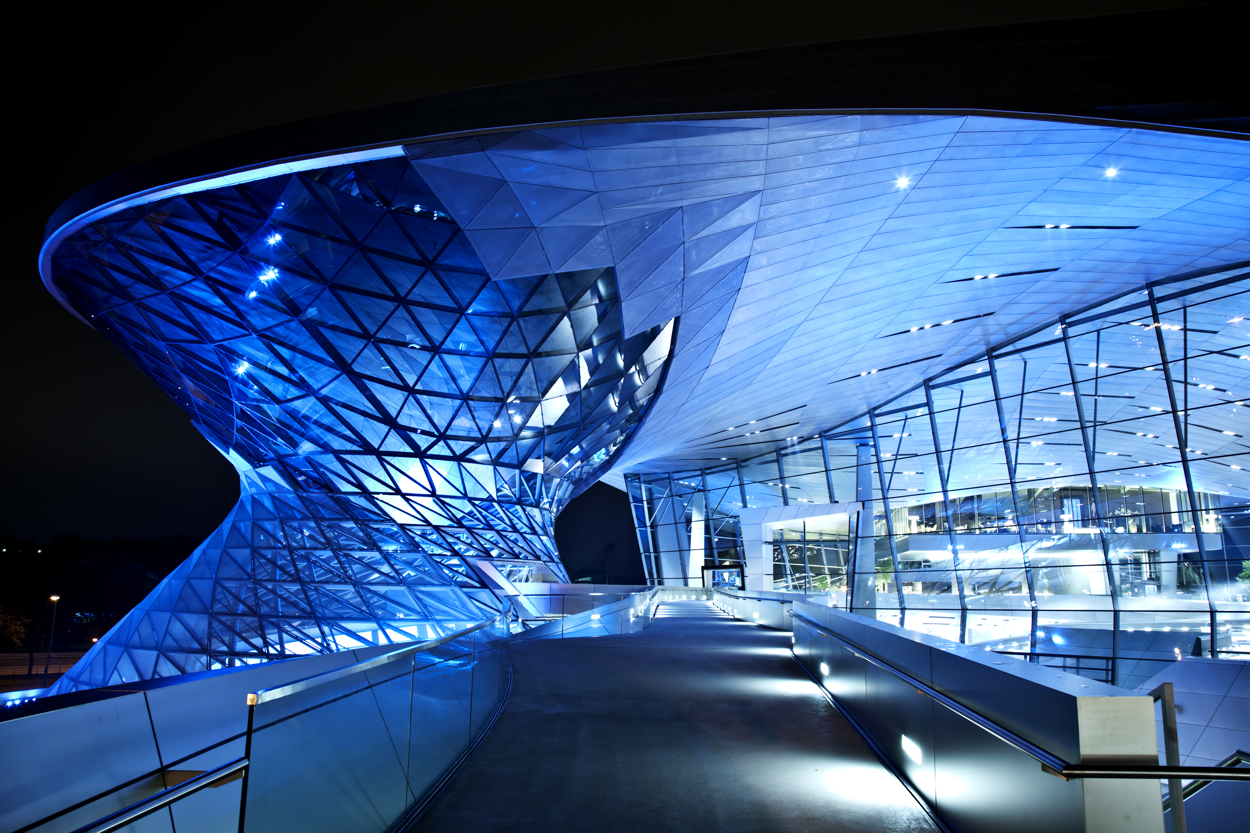 Arquitectura moderna de vidrio y metal azul en la noche, BMW Welt Múnich.