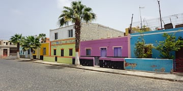 a street with colorful buildings and palm trees