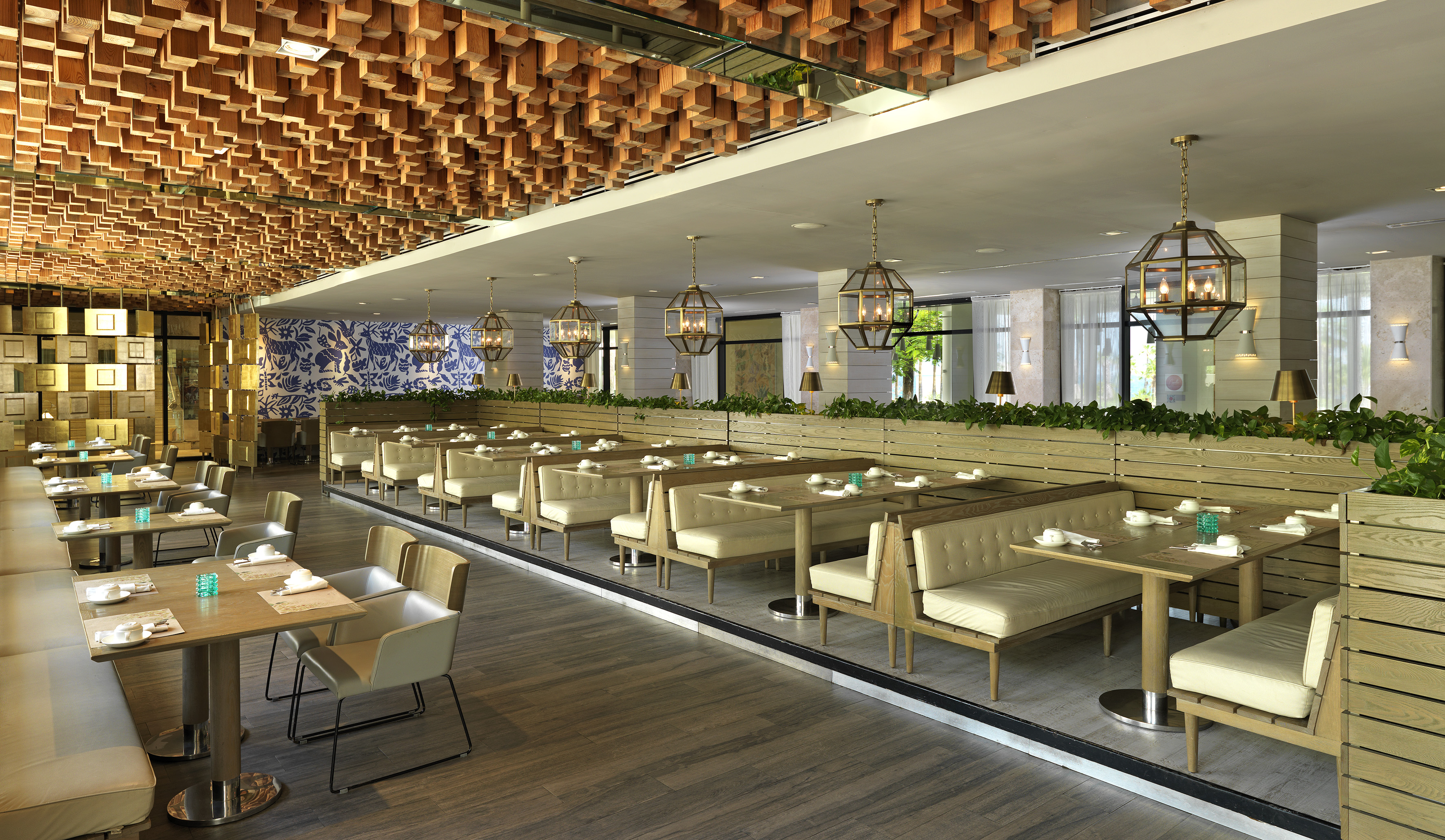 Modern restaurant dining room with wooden ceiling, booths, and pendant lights.