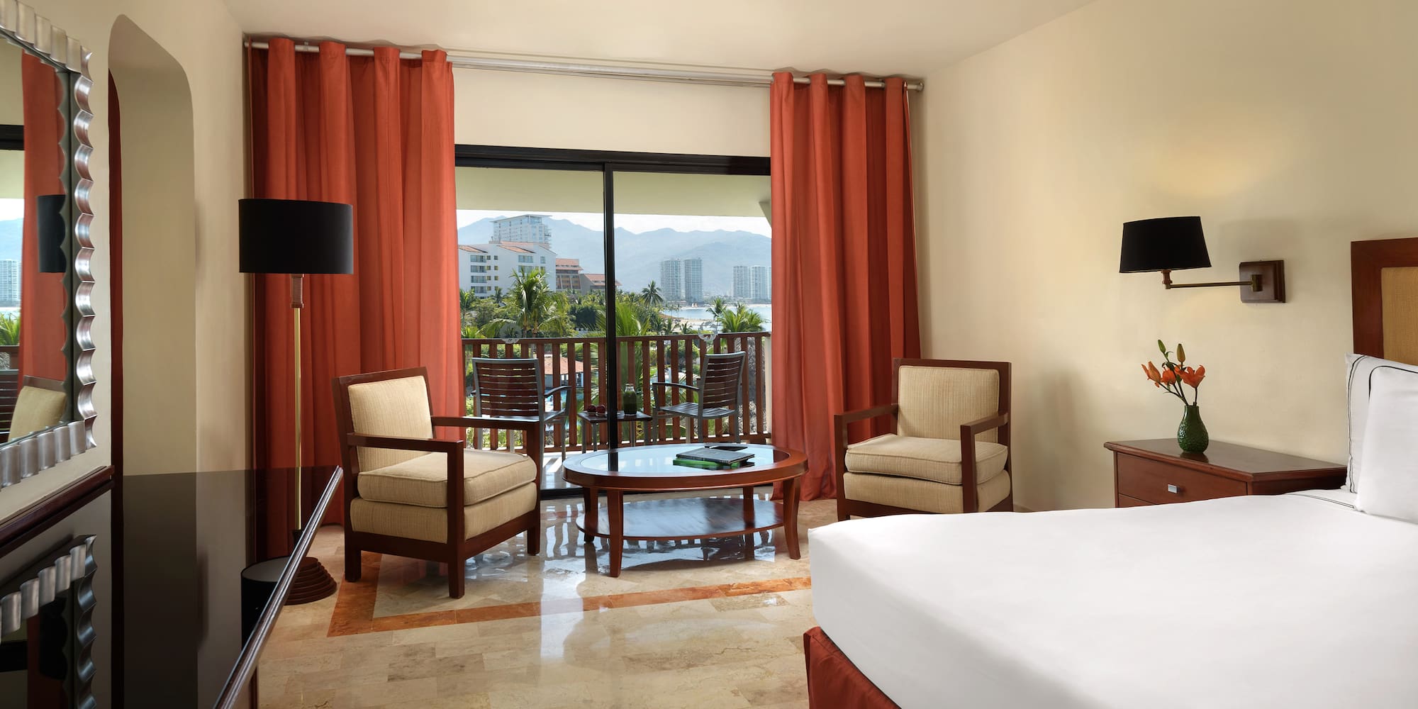 a room with a bed and chairs