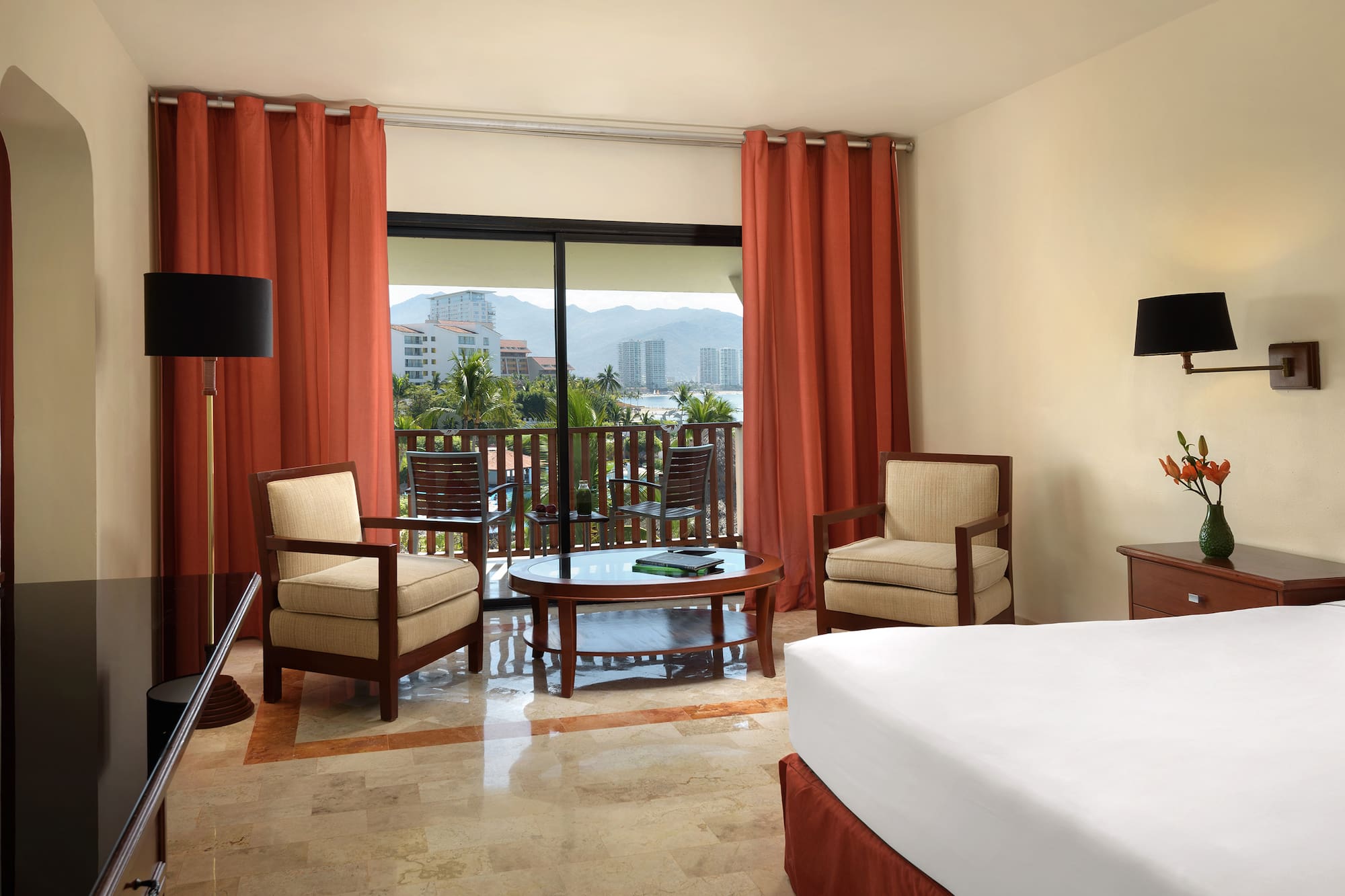 a room with a bed and chairs