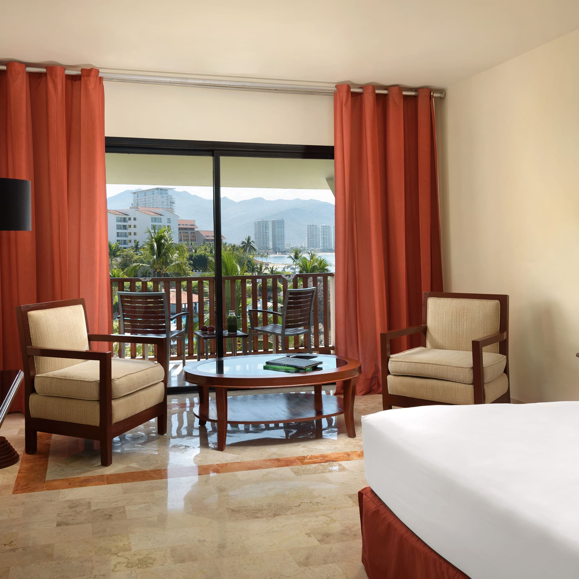 a room with a bed and chairs