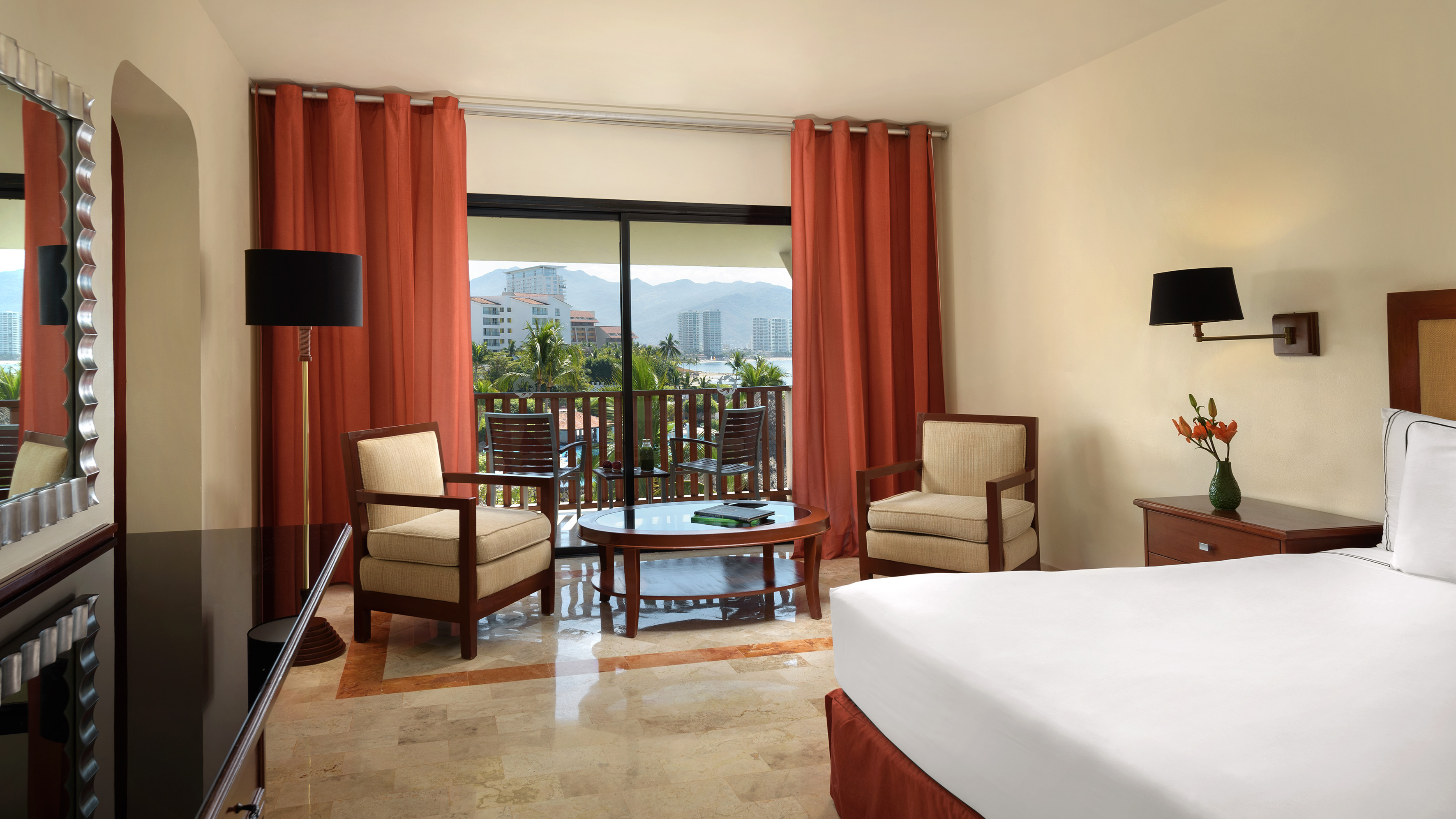 a room with a bed and chairs