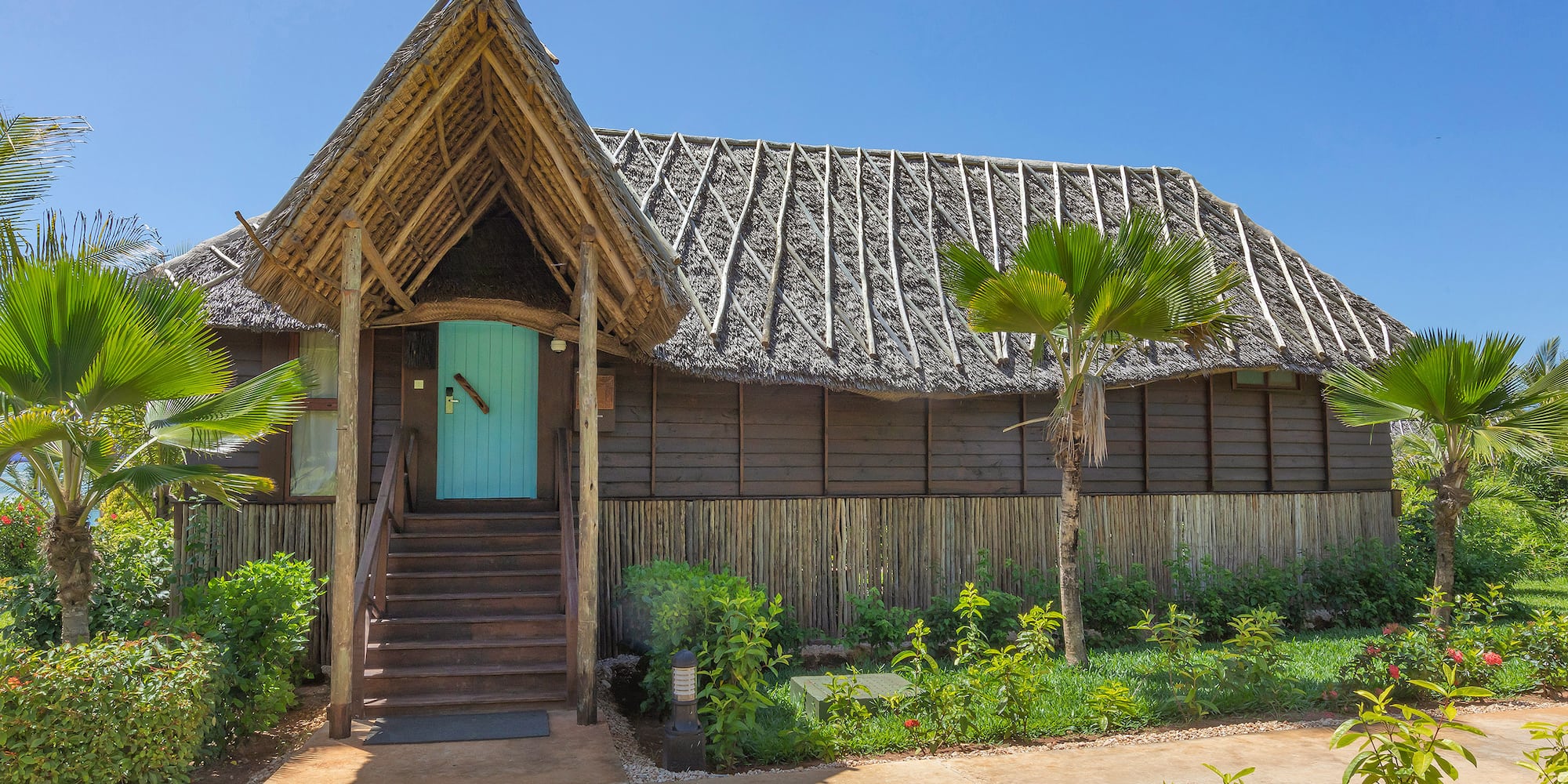 a house with a thatched roof and a blue door