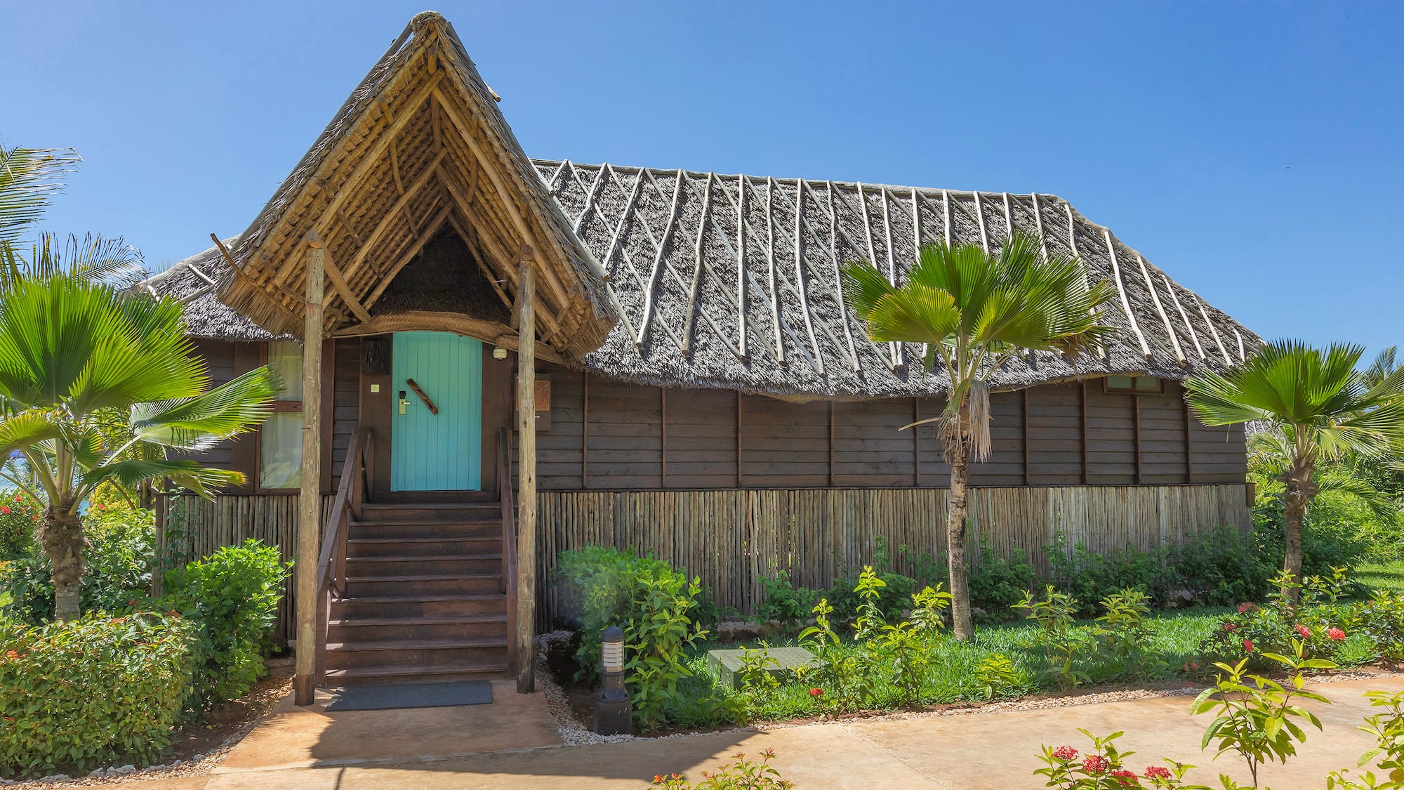 a house with a thatched roof and a blue door