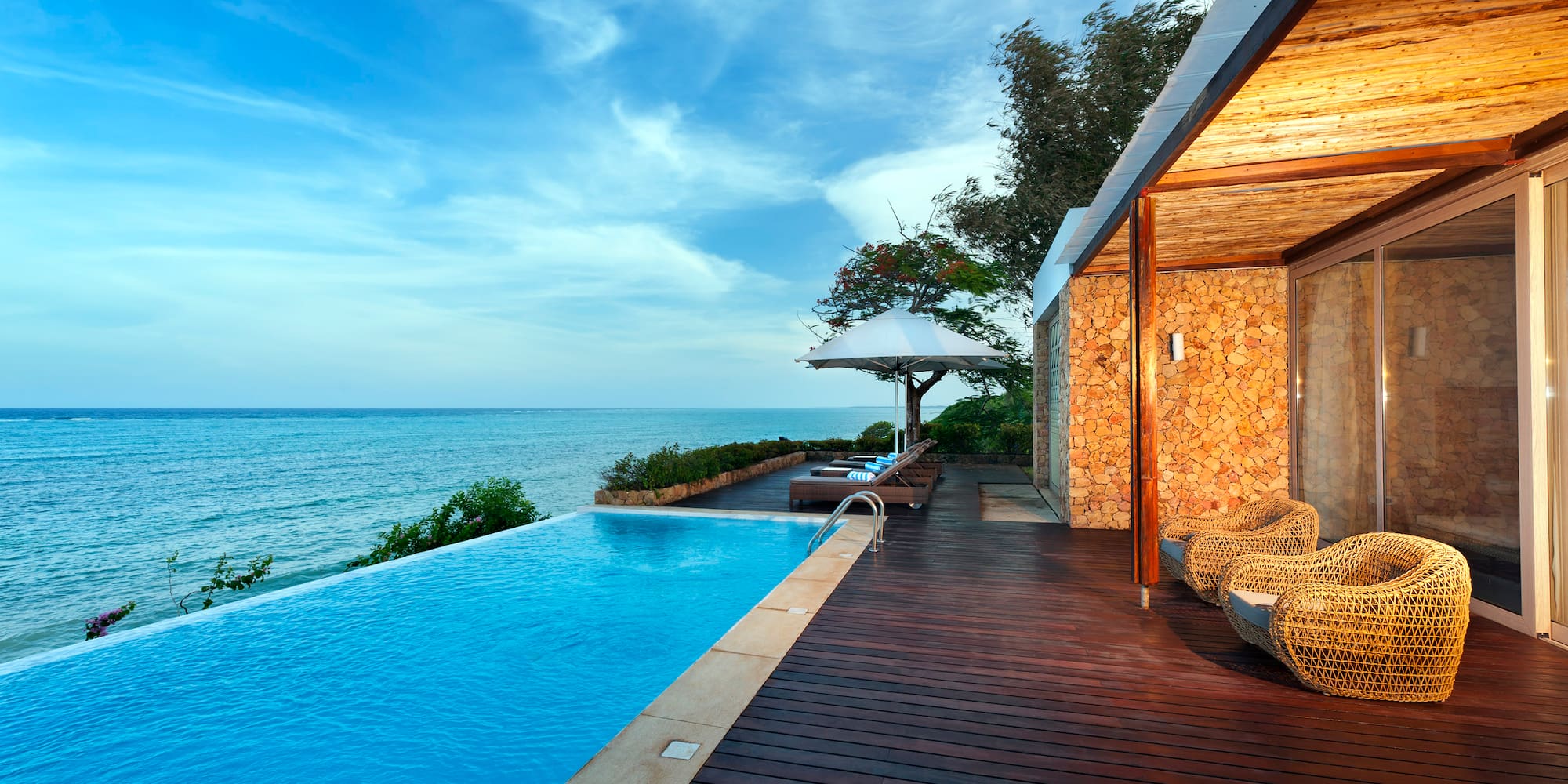 a swimming pool with a deck and chairs by it