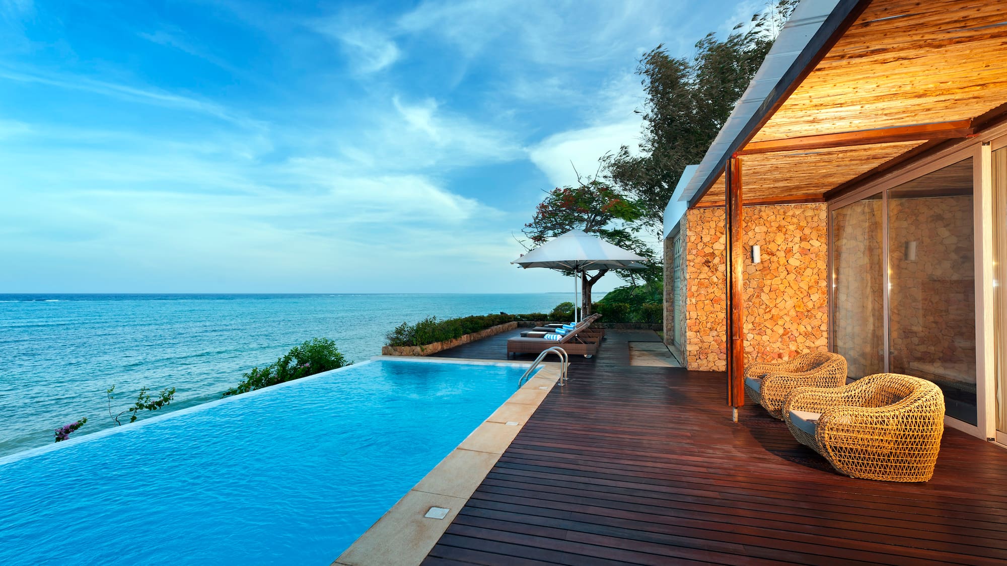 a swimming pool with a deck and chairs by it