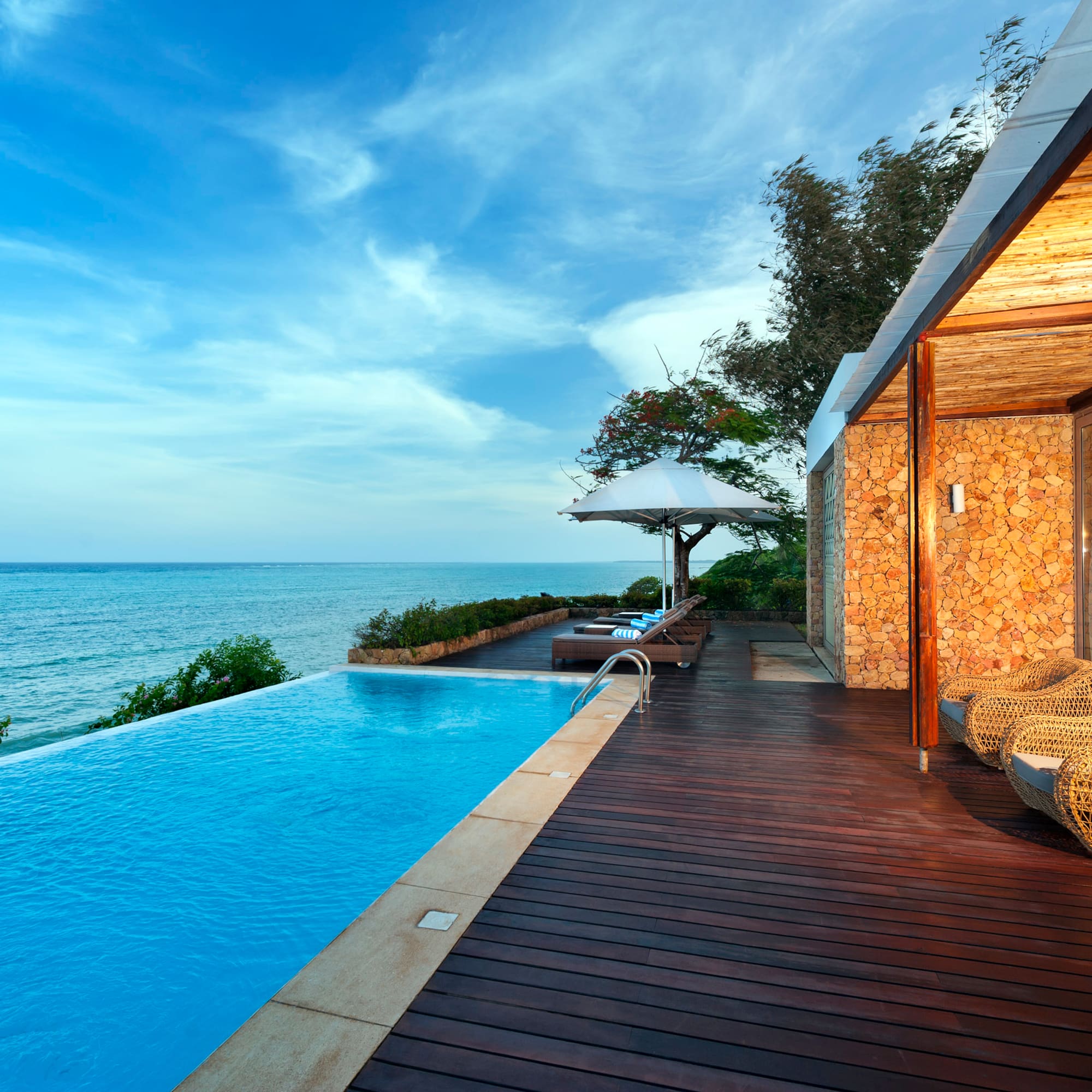 a swimming pool with a deck and chairs by it