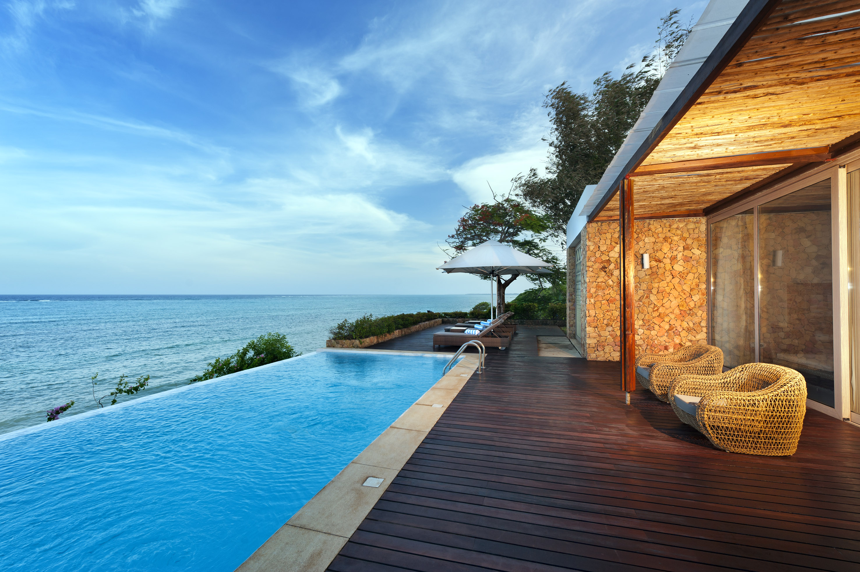 a swimming pool with a deck and chairs by it