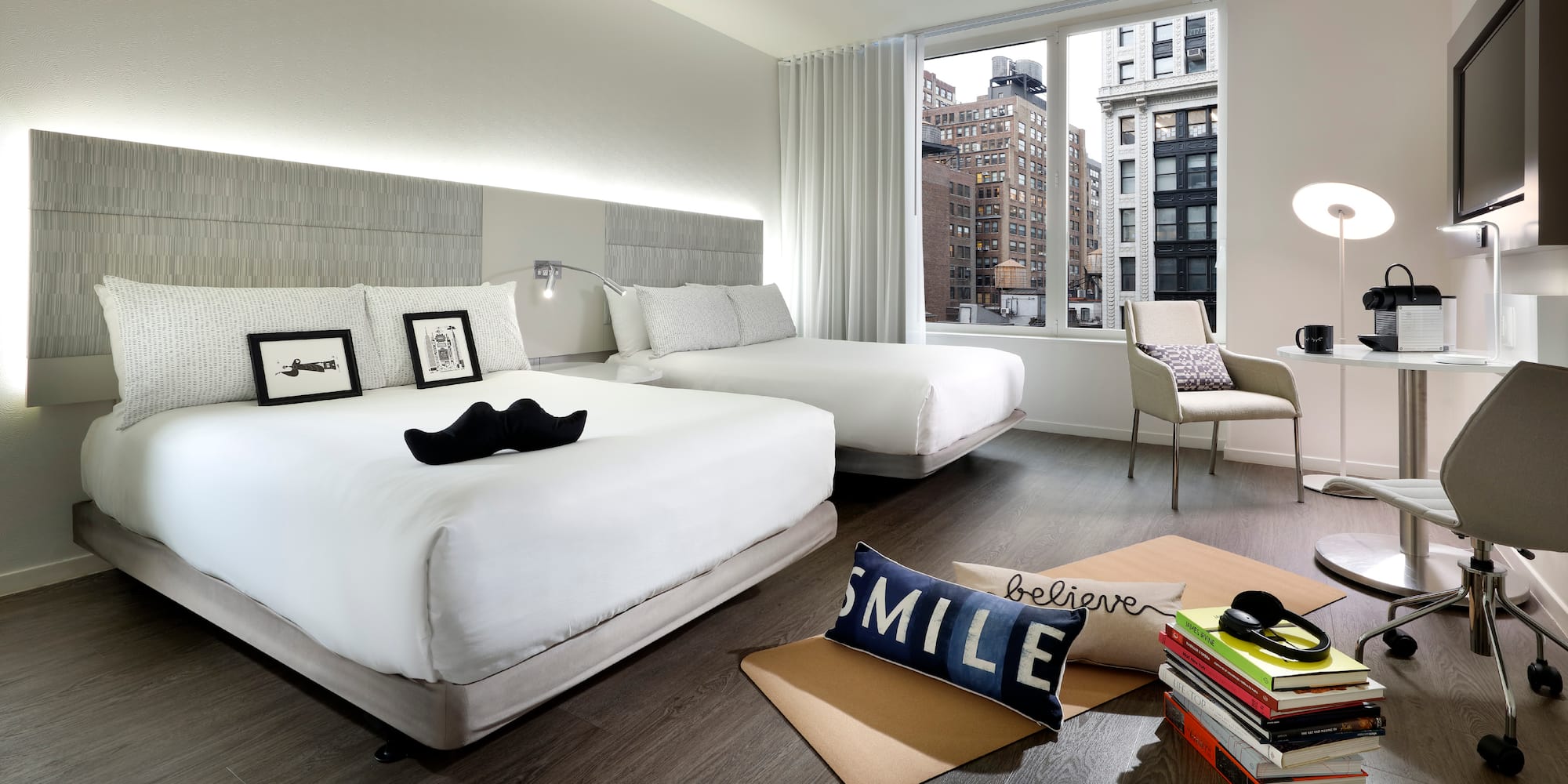 a room with two beds and a chair