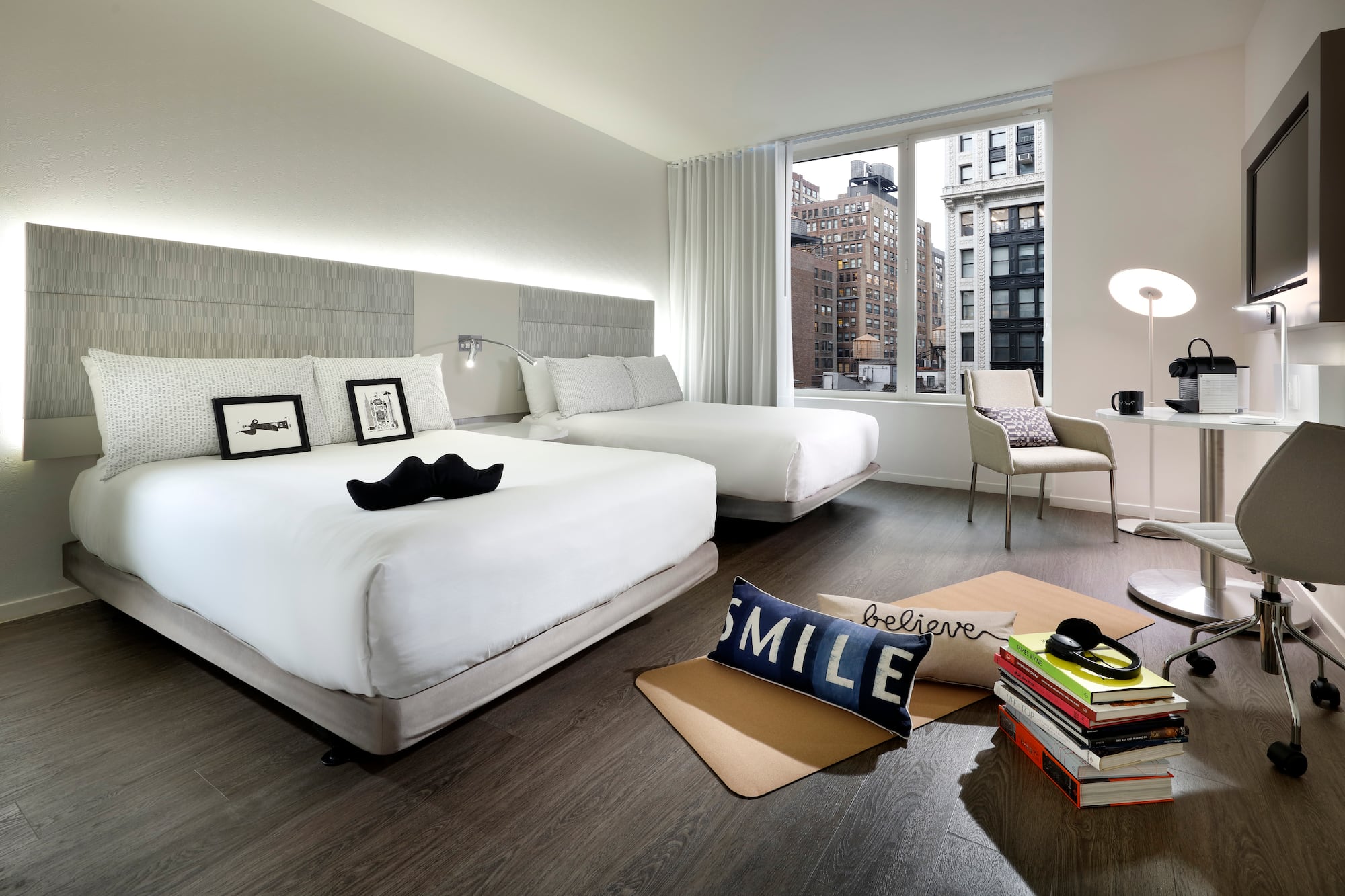 a room with two beds and a chair